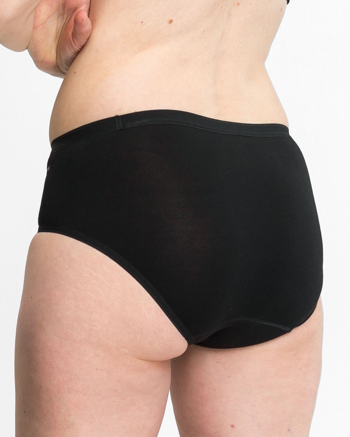 Model trägt Midislip in schwarz aus der Serie Swenja, Ansicht von hinten.