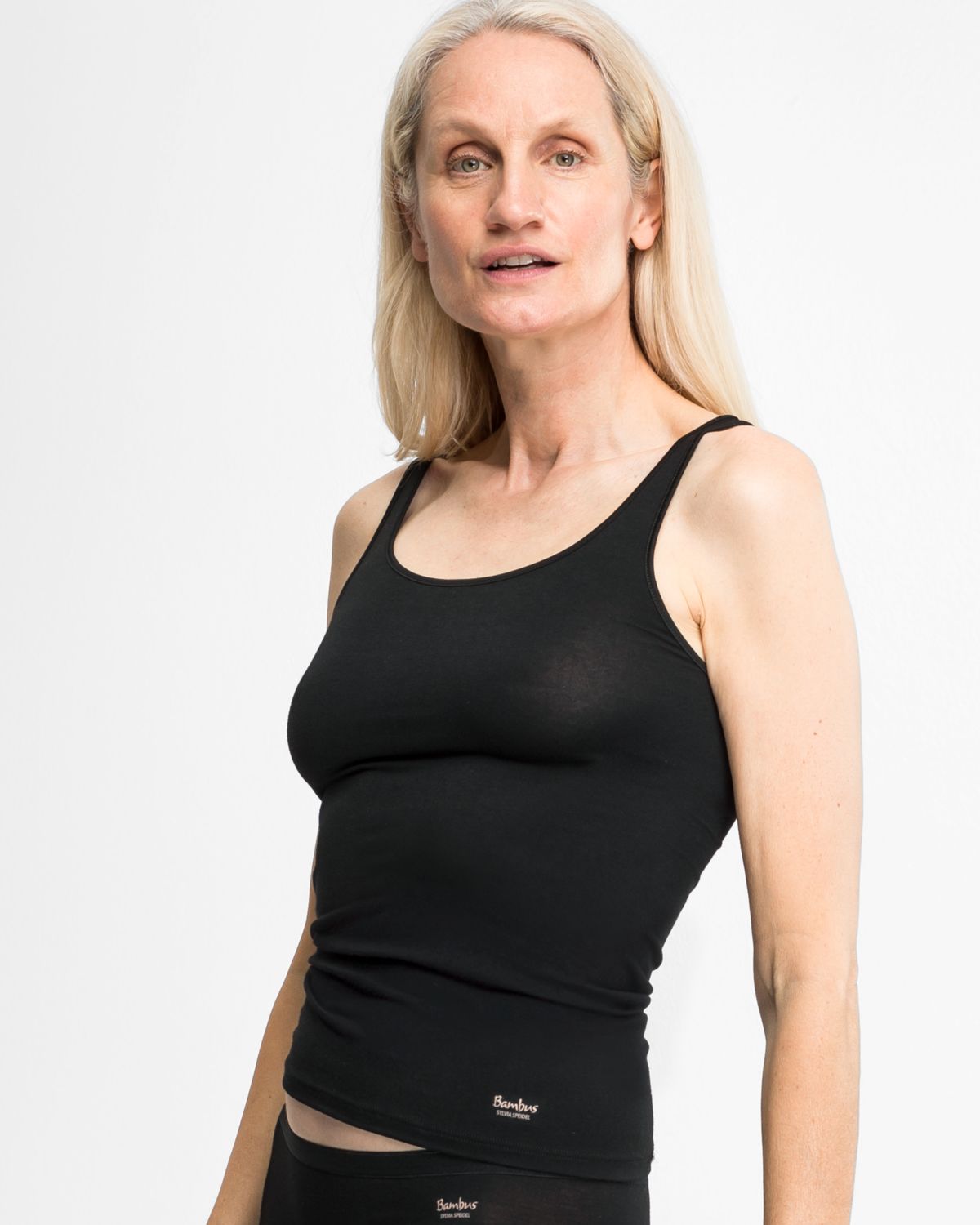 Model trägt Achselhemd in schwarz aus der Serie Swenja, Ansicht von vorne.