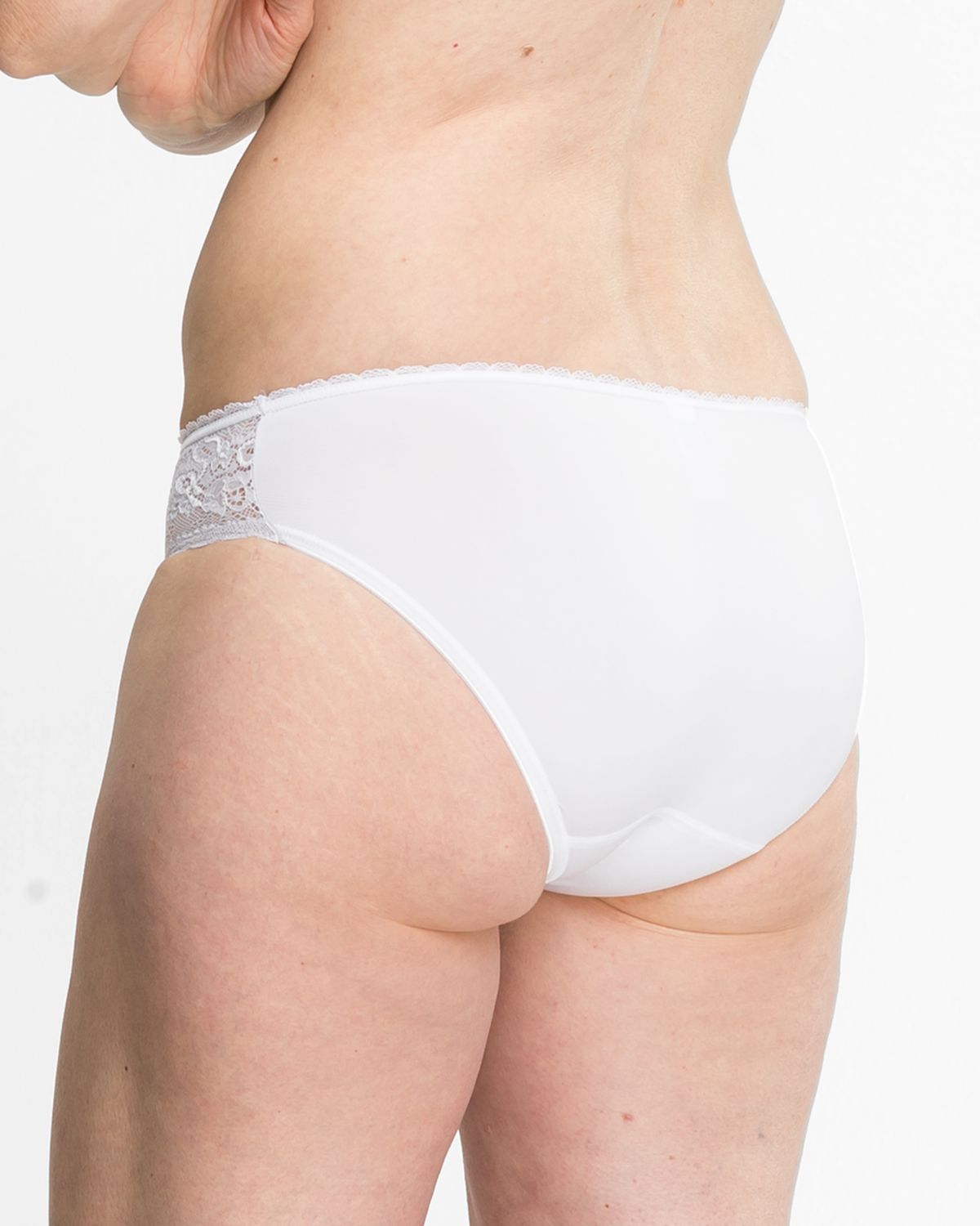 Model trägt Bikinislip in weiß aus der Serie Silvana, Ansicht von hinten.