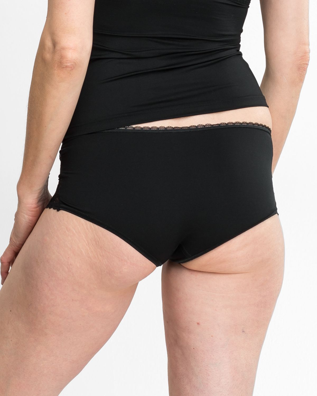 Model trägt Pant in schwarz aus der Serie Silvana, Ansicht von hinten.