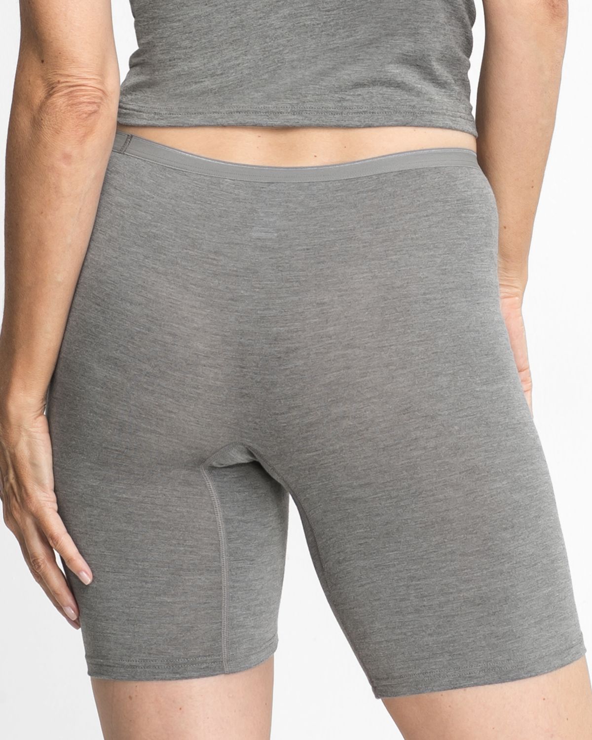 Model trägt Longpant in grau mélé aus der Serie Swenja, Ansicht von hinten.