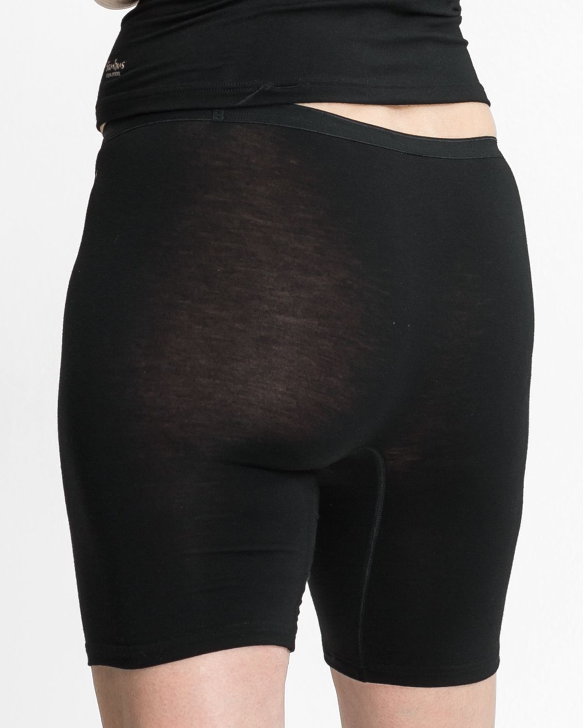 Model trägt Longpant in schwarz aus der Serie Swenja, Ansicht von hinten.