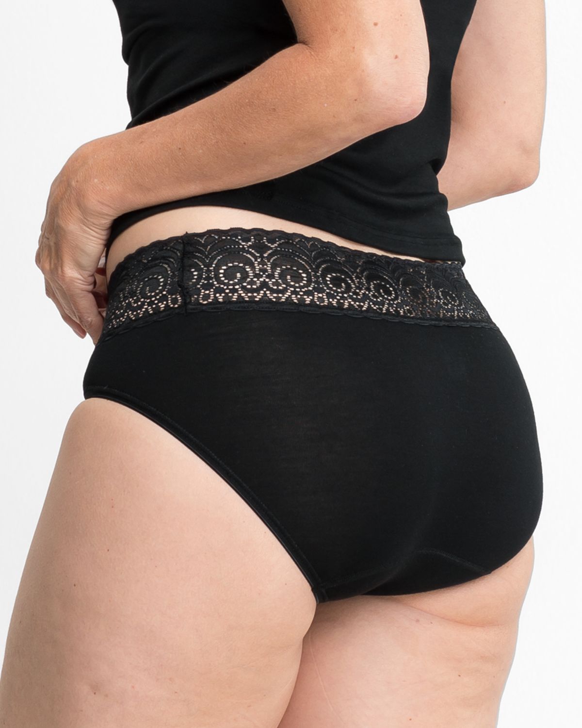 Model trägt Midislip in schwarz aus der Serie Sofia Lace, Ansicht von hinten.