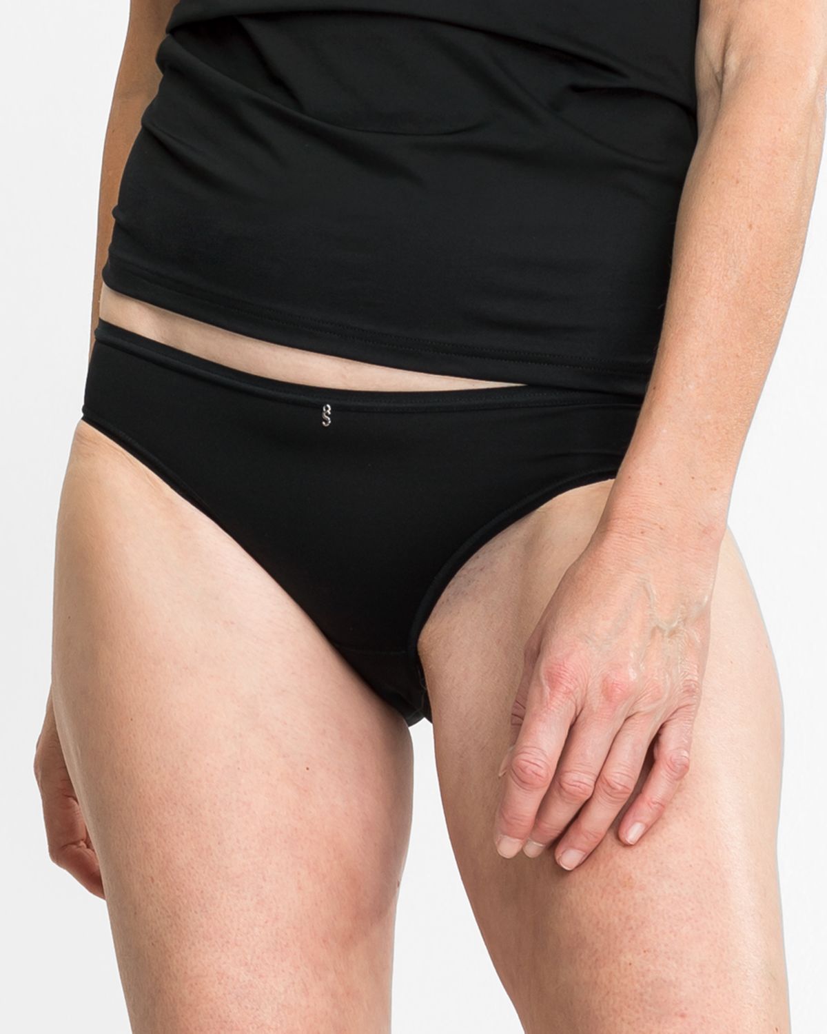 Model trägt Bikinislip in schwarz aus der Serie Sidney, Ansicht von vorne.