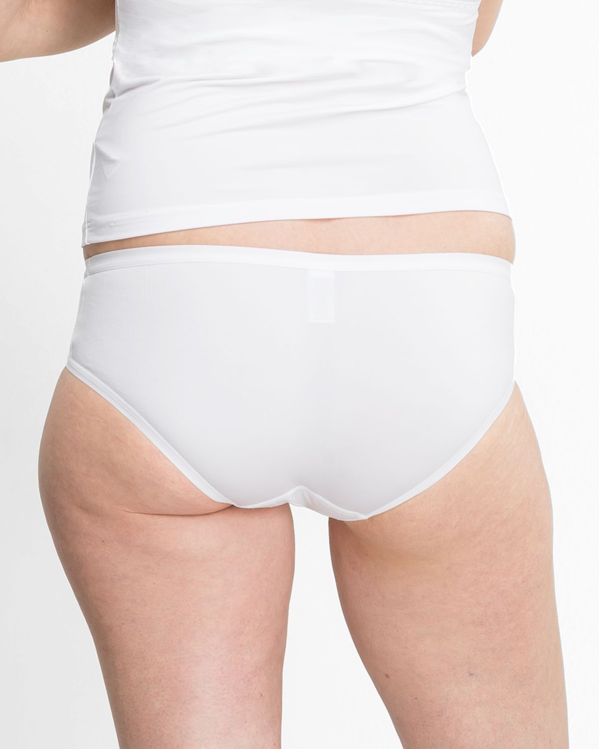 Model trägt Low Hip in weiß aus der Serie Sidney, Ansicht von hinten.