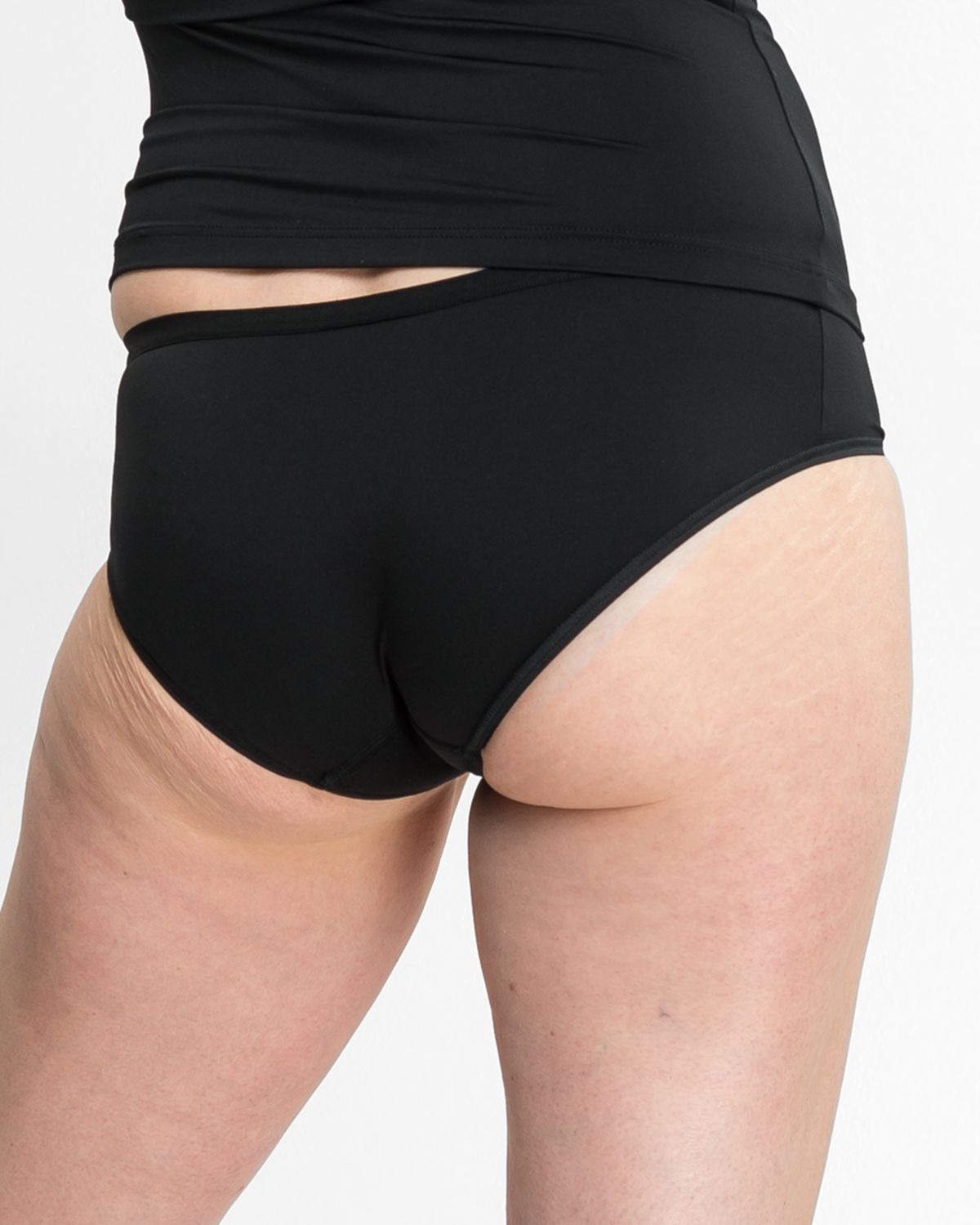 Model trägt Low Hip in schwarz aus der Serie Sidney, Ansicht von hinten.