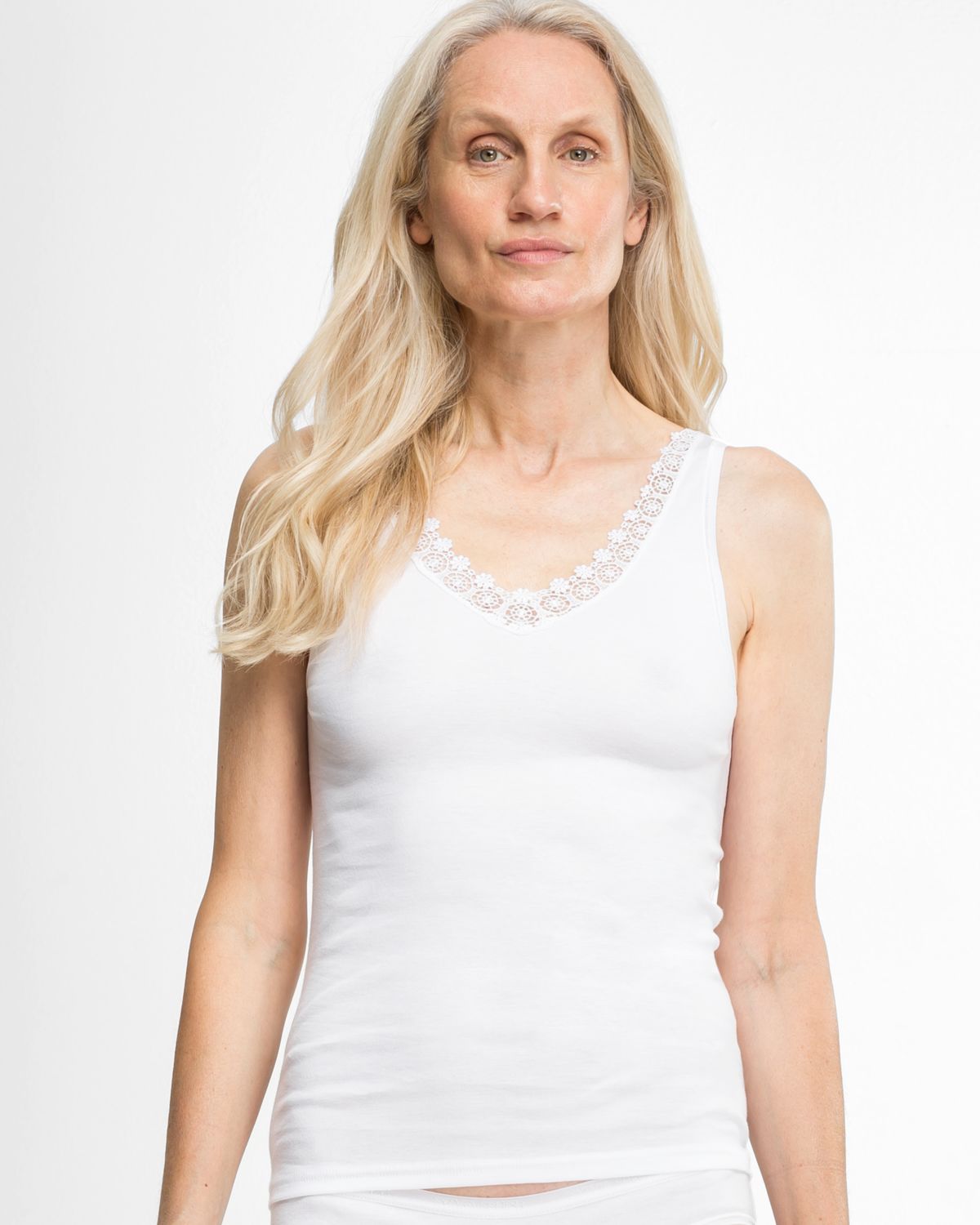 Model trägt Achselhemd in weiß aus der Serie Silke, Ansicht von vorne.