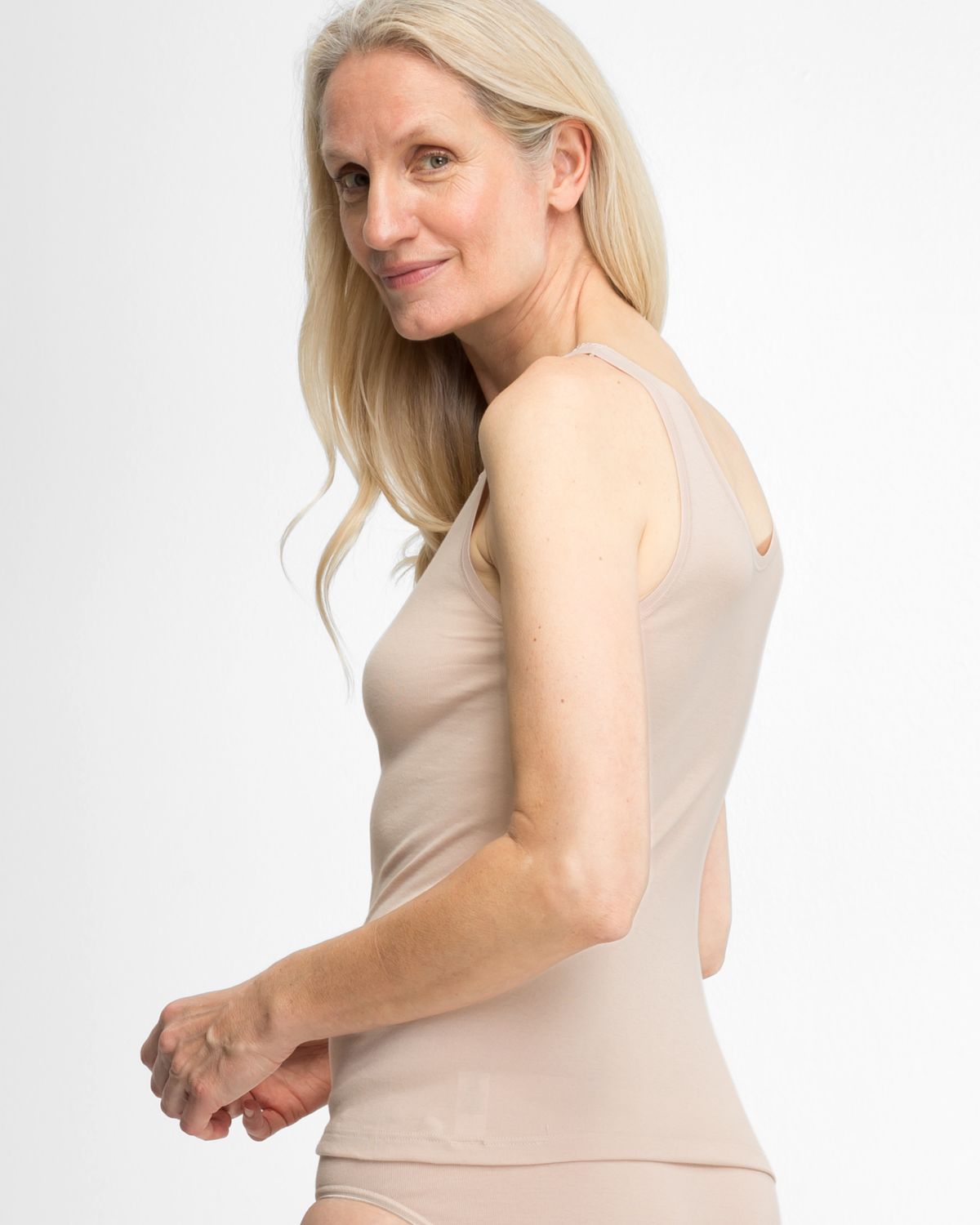 Model trägt Achselhemd in honey aus der Serie Silke, Ansicht von hinten.