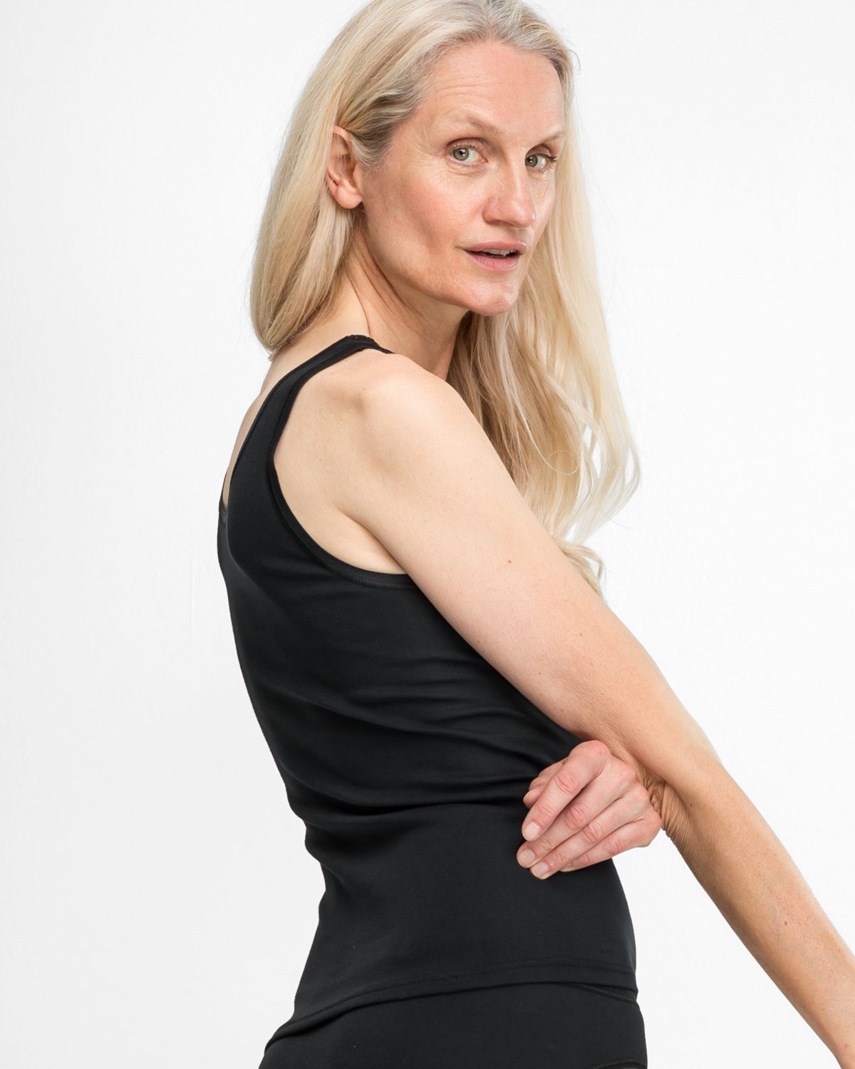 Model trägt Achselhemd in schwarz aus der Serie Silke, Ansicht von hinten.