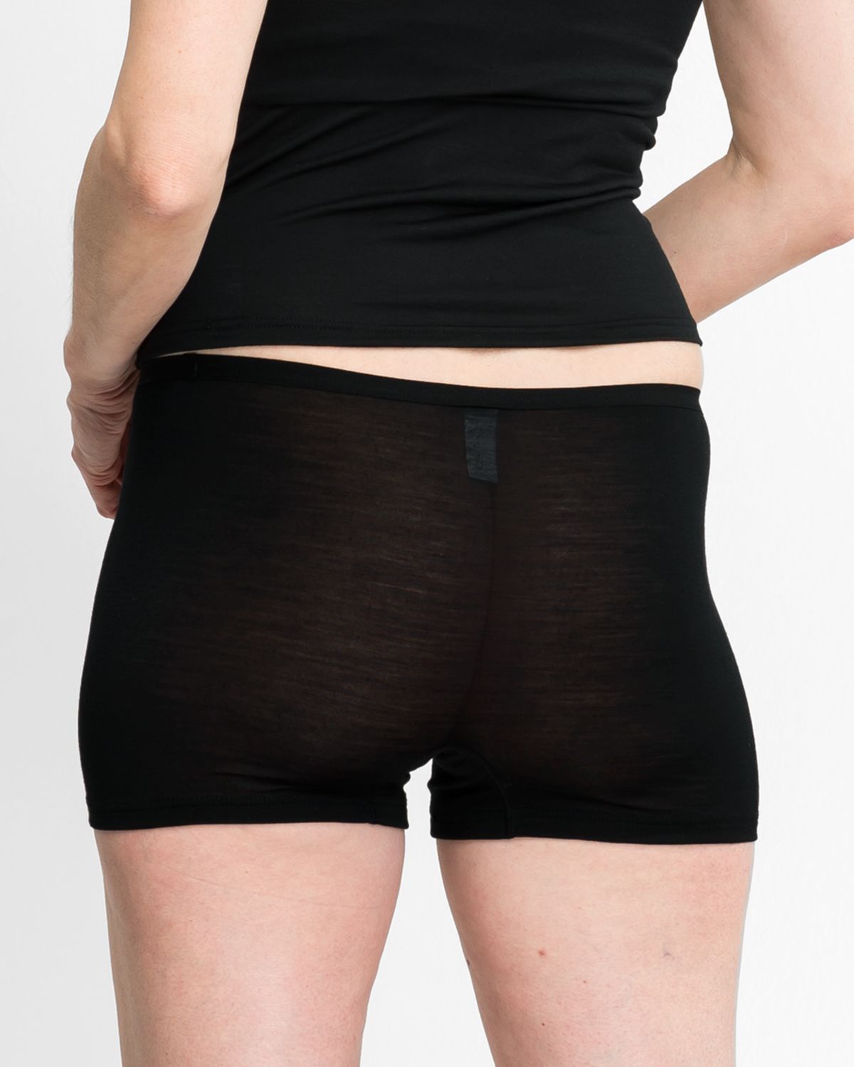 Model trägt Pant in schwarz aus der Serie Sanja, Ansicht von hinten.