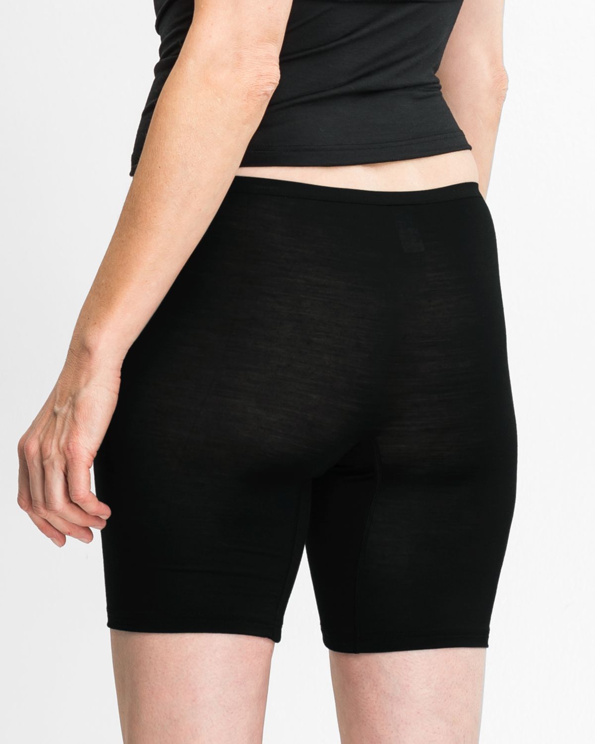 Model trägt Longpant in schwarz aus der Serie Sanja, Ansicht von hinten.