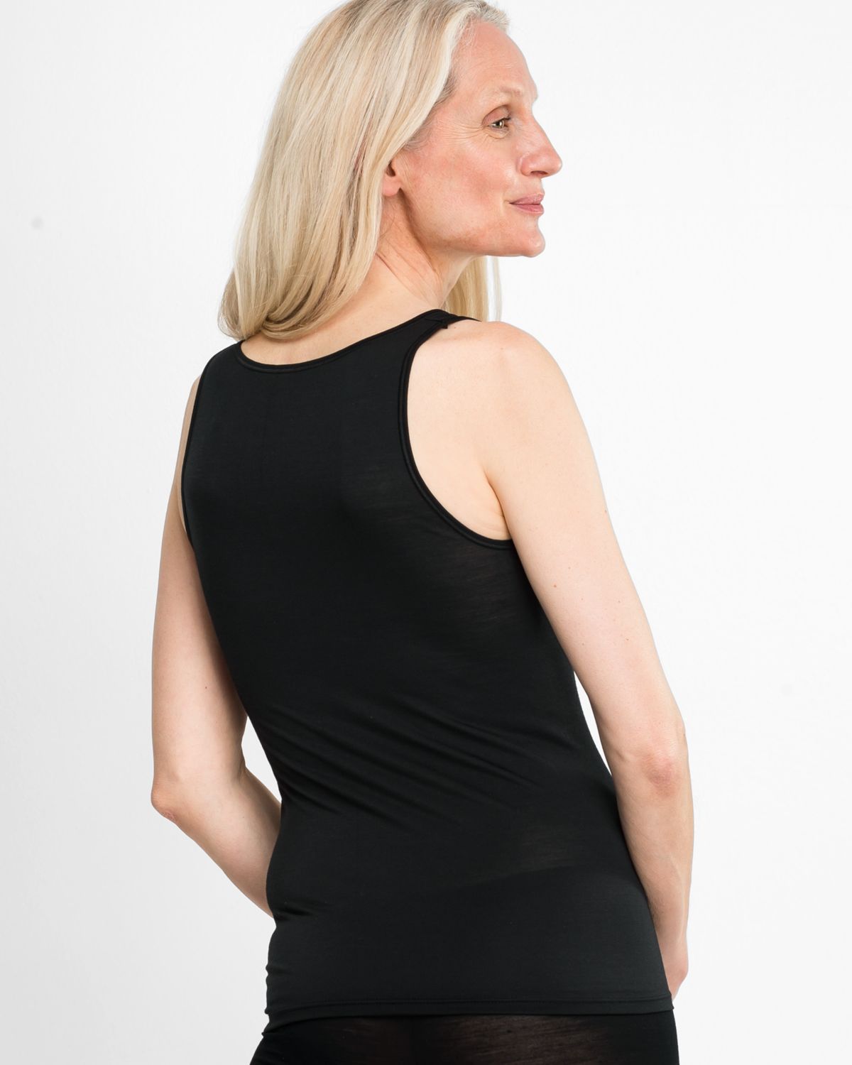 Model trägt Achselhemd in schwarz aus der Serie Sanja, Ansicht von hinten.