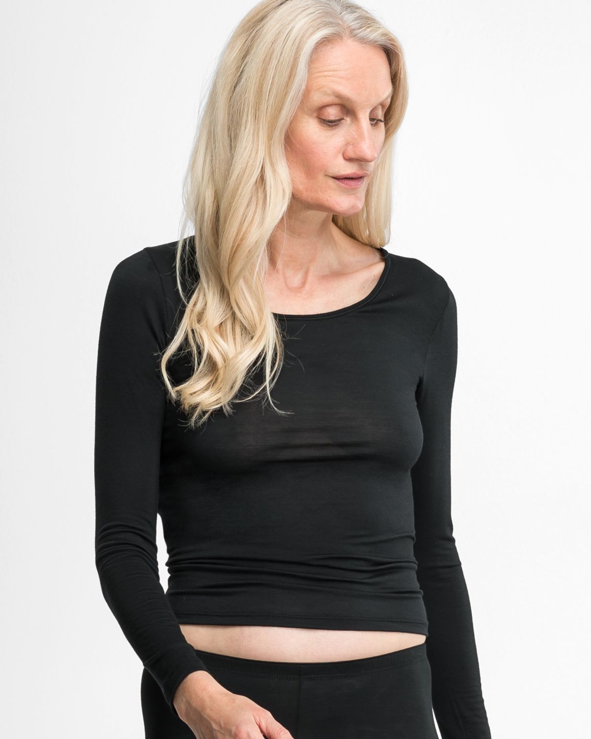 Model trägt Shirt 1/1 Arm in schwarz aus der Serie Sanja, Ansicht von vorne.