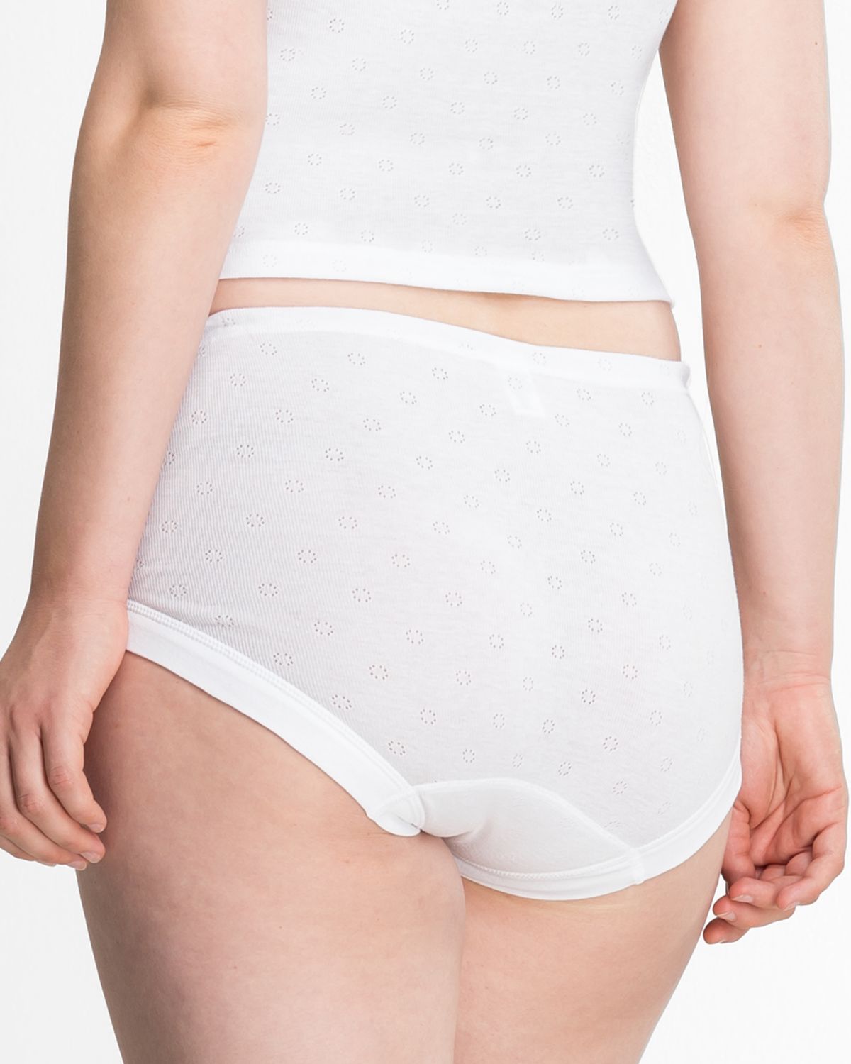 Model trägt Taillenslip in weiß aus der Serie Nina, Ansicht von hinten.