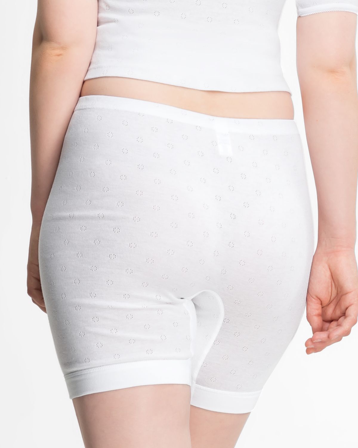 Model trägt Langbeinschlüpfer in weiß aus der Serie Nina, Ansicht von hinten.