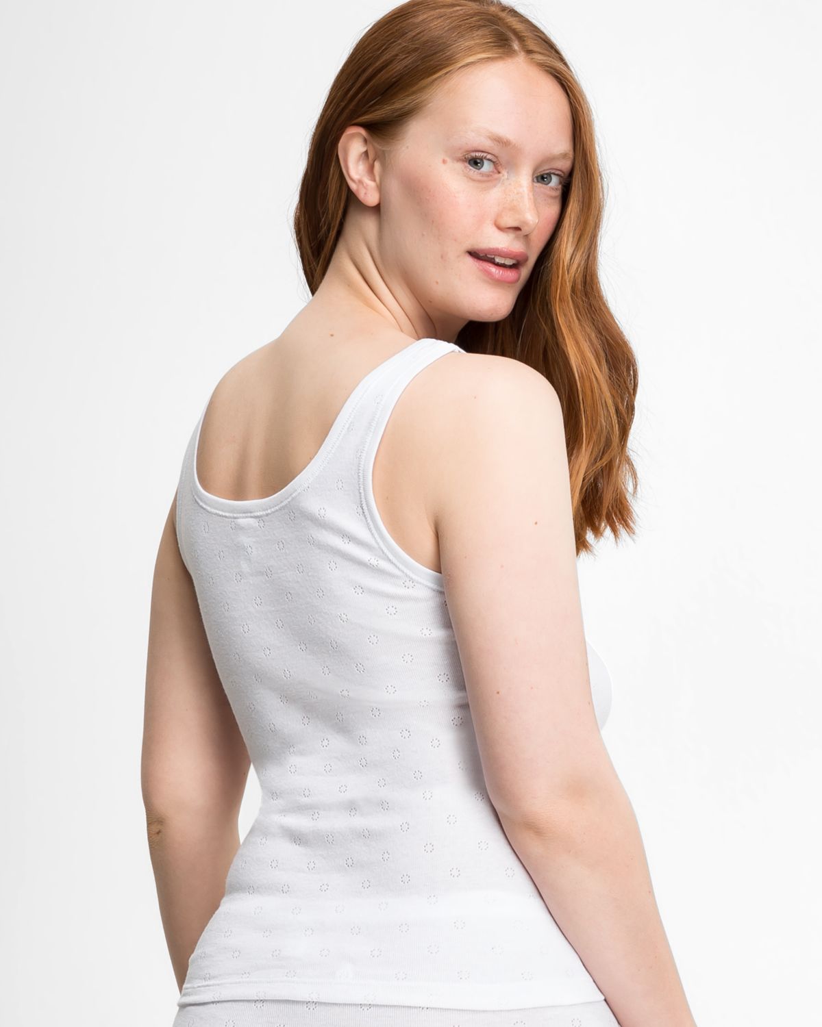 Model trägt Achselhemd in weiß aus der Serie Nina, Ansicht von hinten.