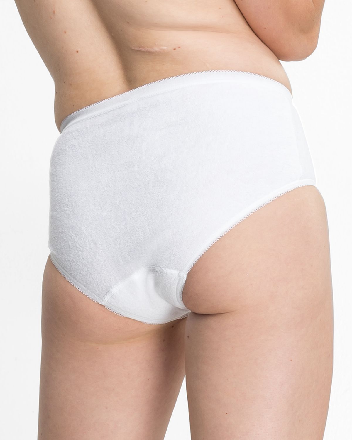 Model trägt Hüftslip in weiß aus der Serie Britta, Ansicht von hinten.