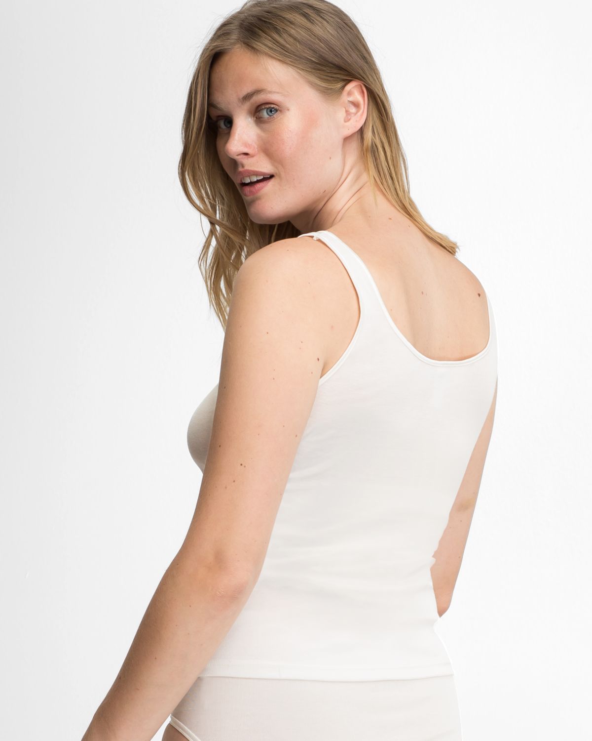 Model trägt Achselhemd in elfenbein aus der Serie Nele, Ansicht von hinten.