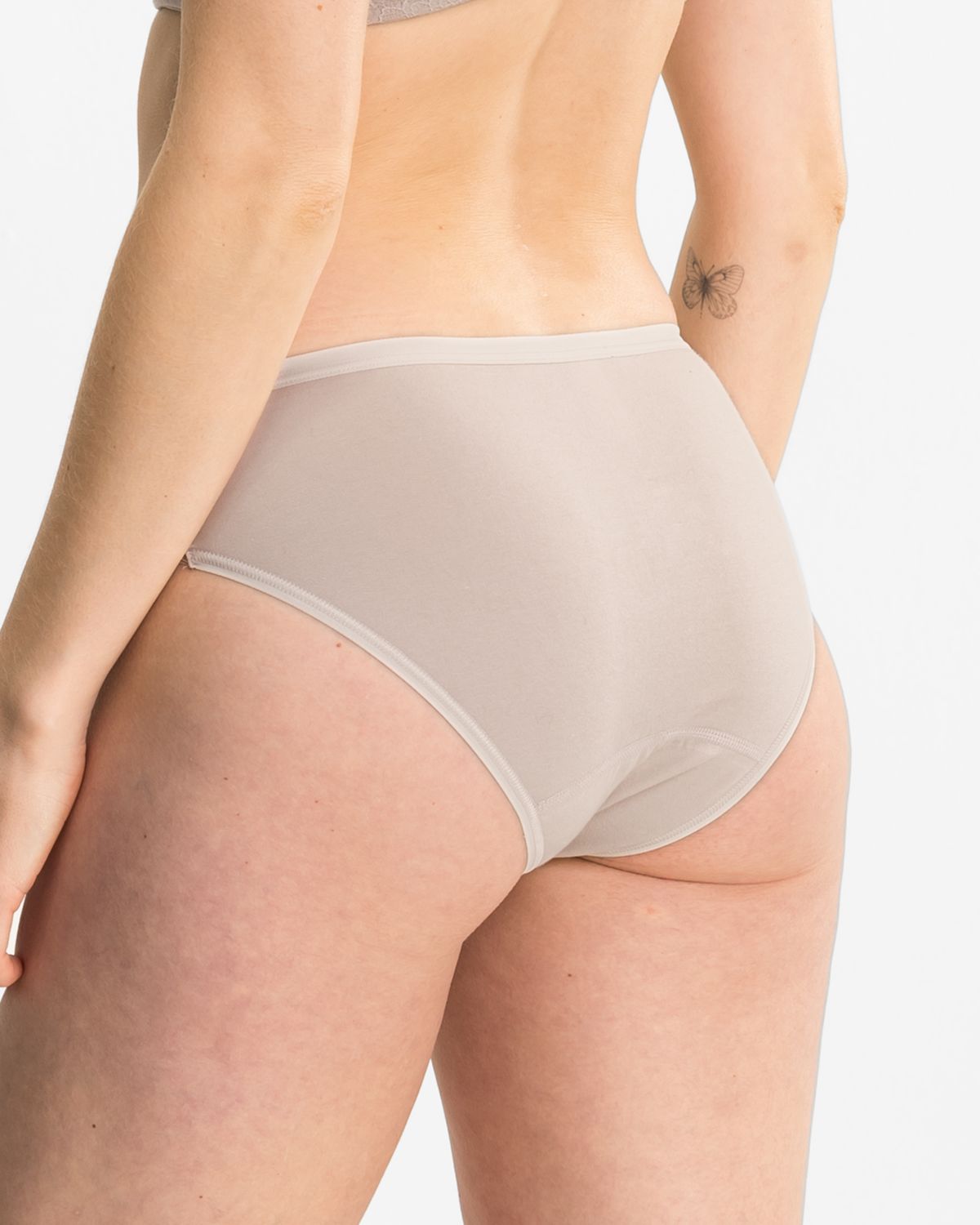 Model trägt Bikinislip in cashew aus der Serie Ronja, Ansicht von hinten.