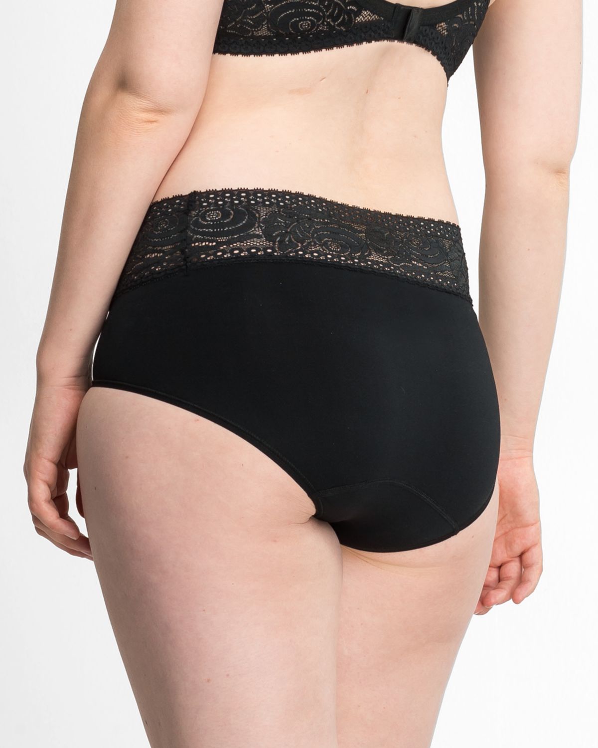 Model trägt Classic Slip in schwarz aus der Serie Inshape, Ansicht von hinten.
