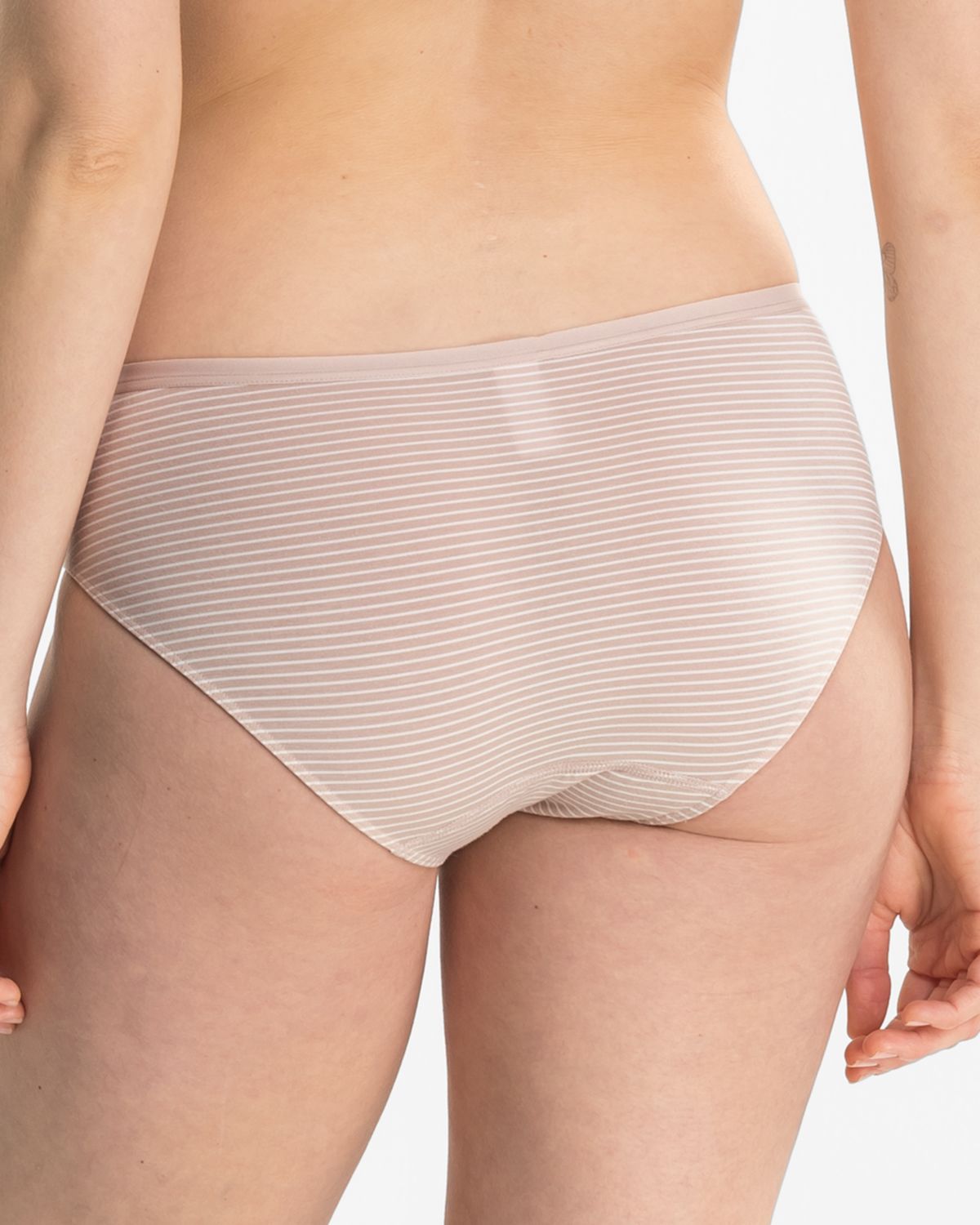 Model trägt Bikinislip in cashew / off white aus der Serie Rebecca, Ansicht von hinten.