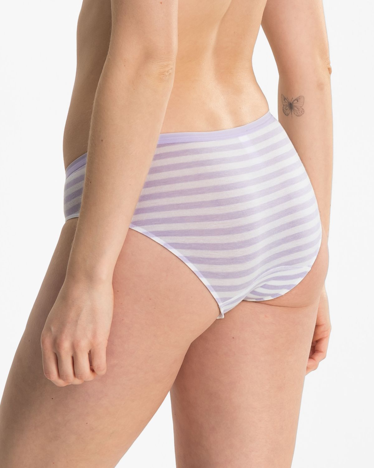 Model trägt Bikinislip in lavendel / off white aus der Serie Regina, Ansicht von hinten.
