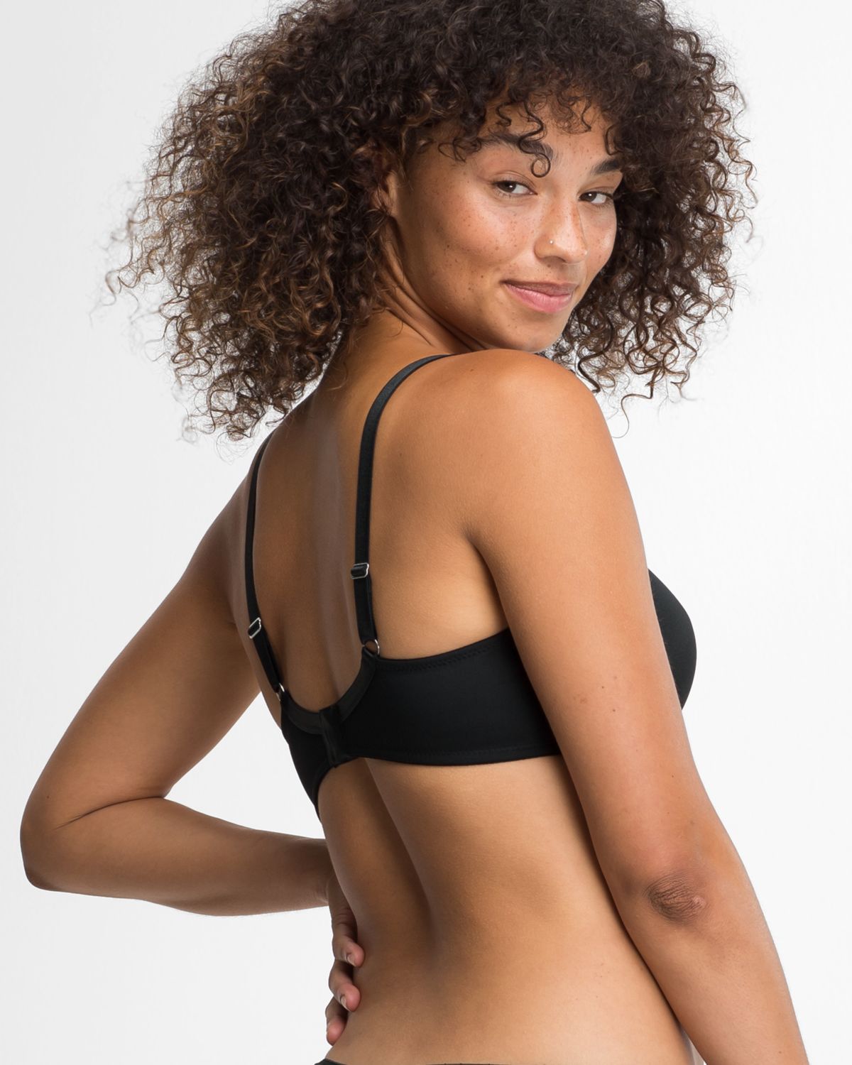 Model trägt Schalen BH Spacer Cup in schwarz aus der Serie Magic hip, Ansicht von hinten.