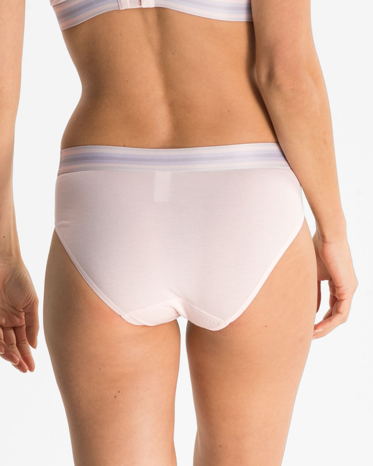 Model trägt Bikinislip in lychee mélé aus der Serie Ruby, Ansicht von hinten.