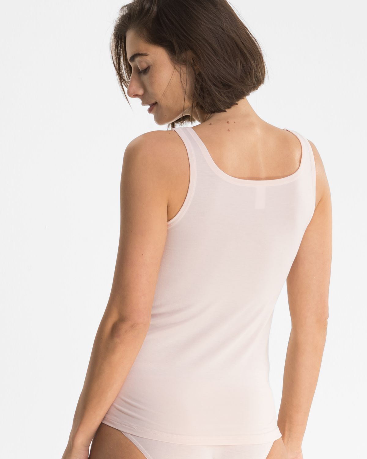 Model trägt Achselhemd in lychee mélé aus der Serie Ruby, Ansicht von hinten.