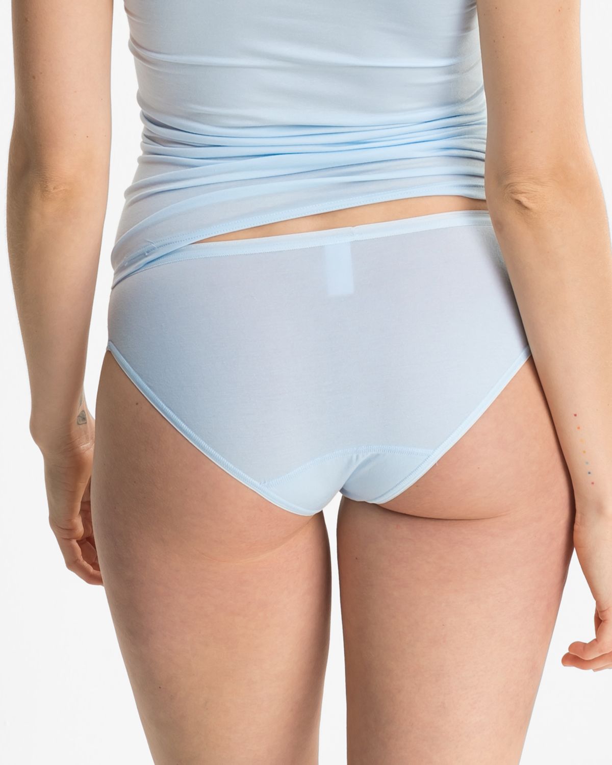 Model trägt Bikinislip in aquamarin aus der Serie Romy, Ansicht von hinten.