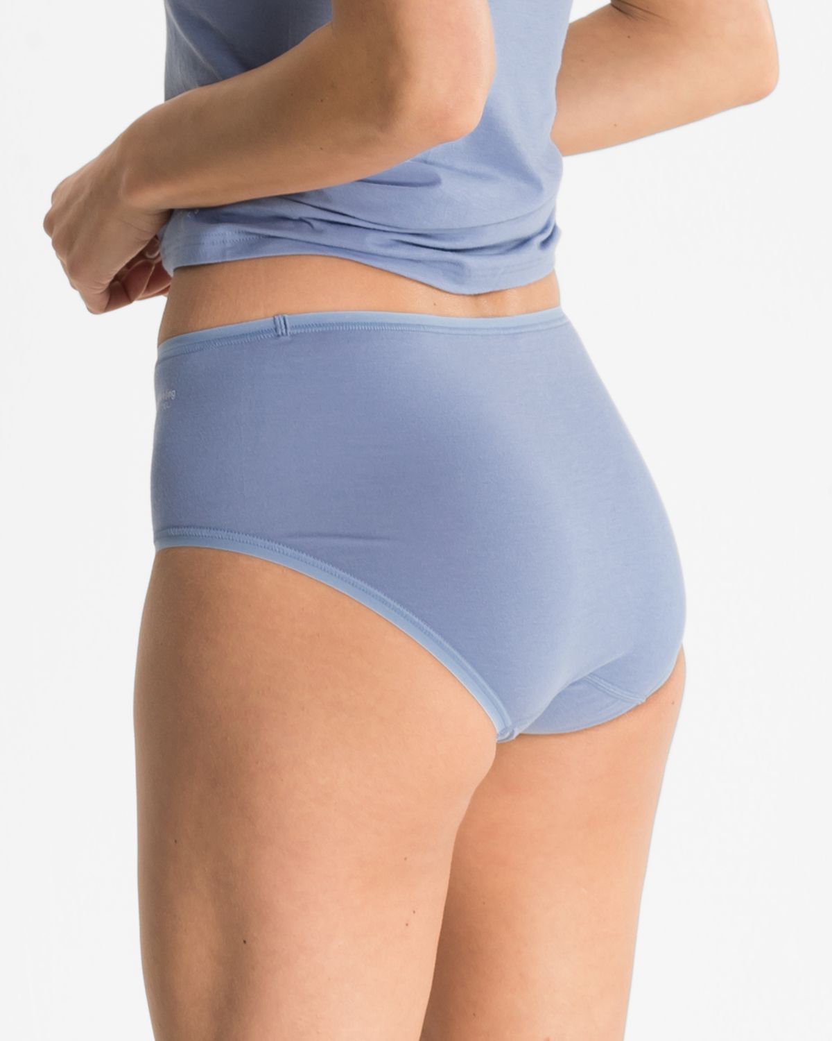 Model trägt Maxislip in blue aus der Serie Softfeeling, Ansicht von hinten.