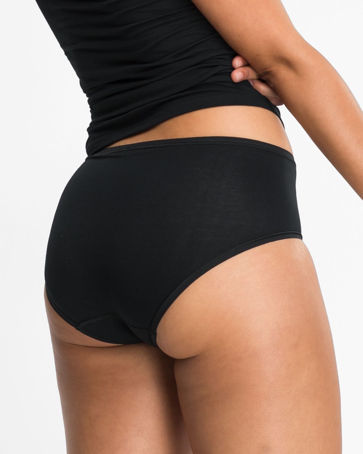 Model trägt Maxislip in schwarz aus der Serie Softfeeling, Ansicht von hinten.