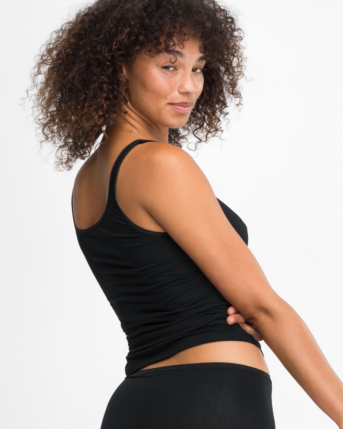 Model trägt Trägerhemd in schwarz aus der Serie Softfeeling, Ansicht von hinten.