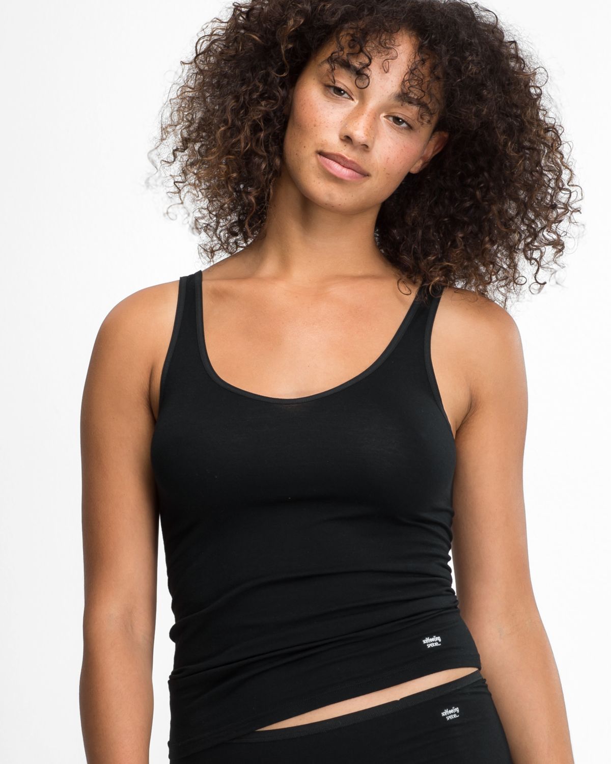Model trägt Trägerhemd in schwarz aus der Serie Softfeeling, Ansicht von vorne.
