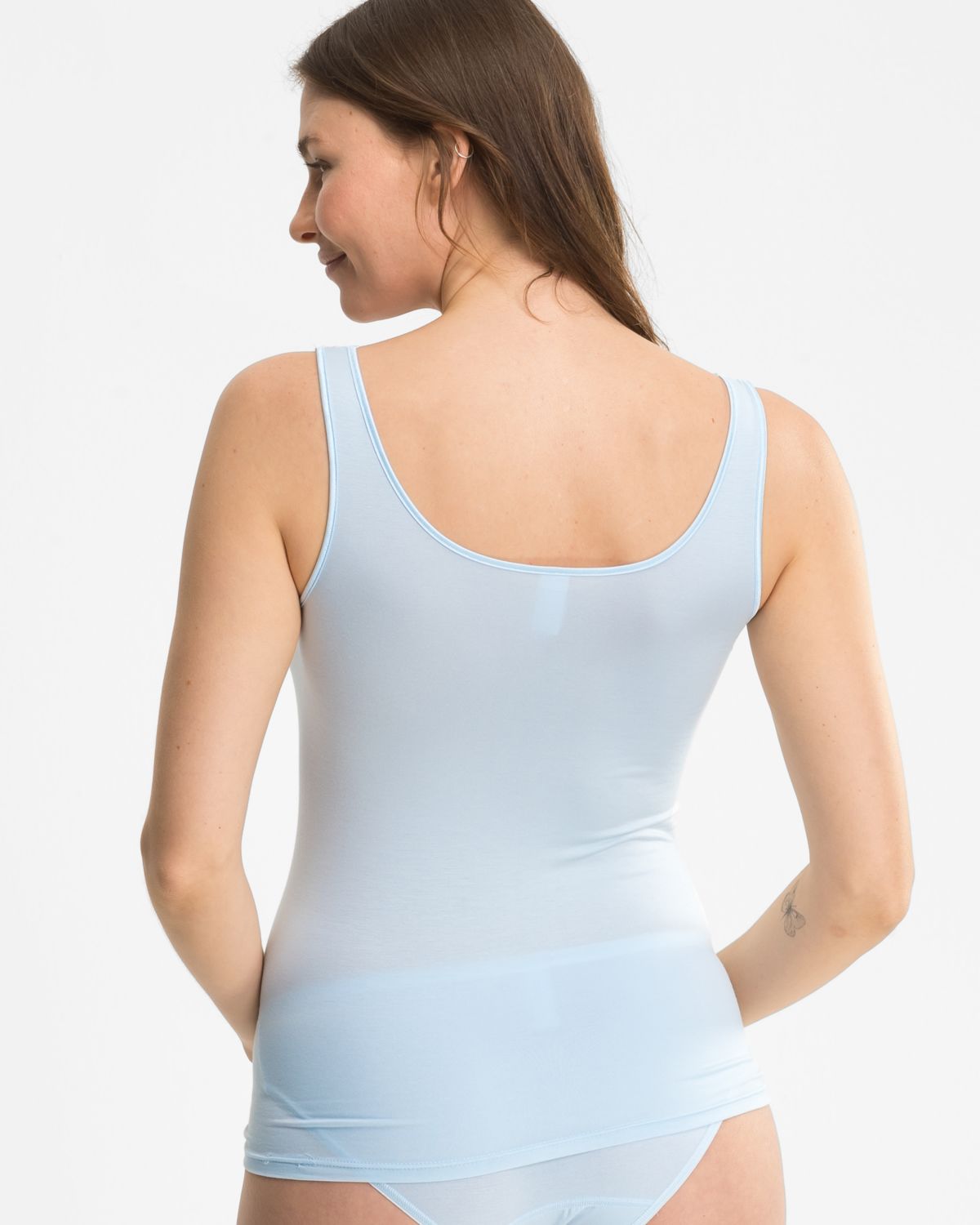 Model trägt Achselhemd in aquamarin aus der Serie Romy, Ansicht von hinten.