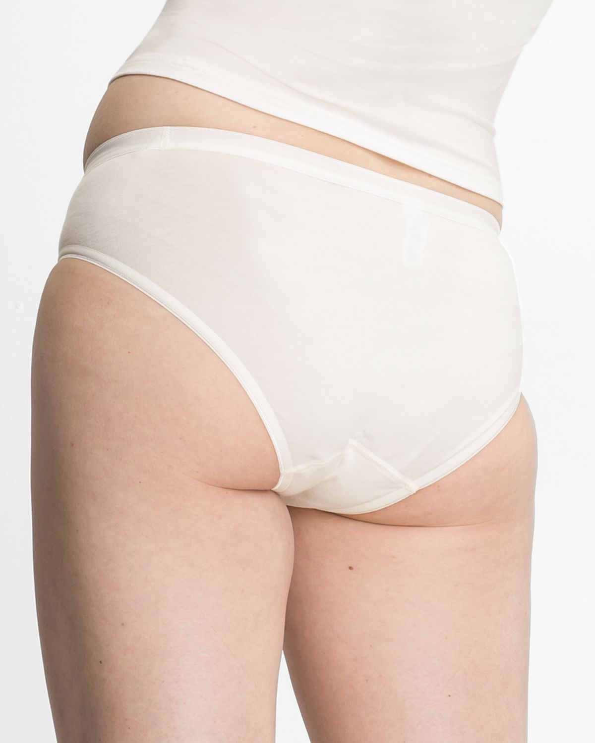 Model trägt Minislip in elfenbein aus der Serie Bambus, Ansicht von hinten.