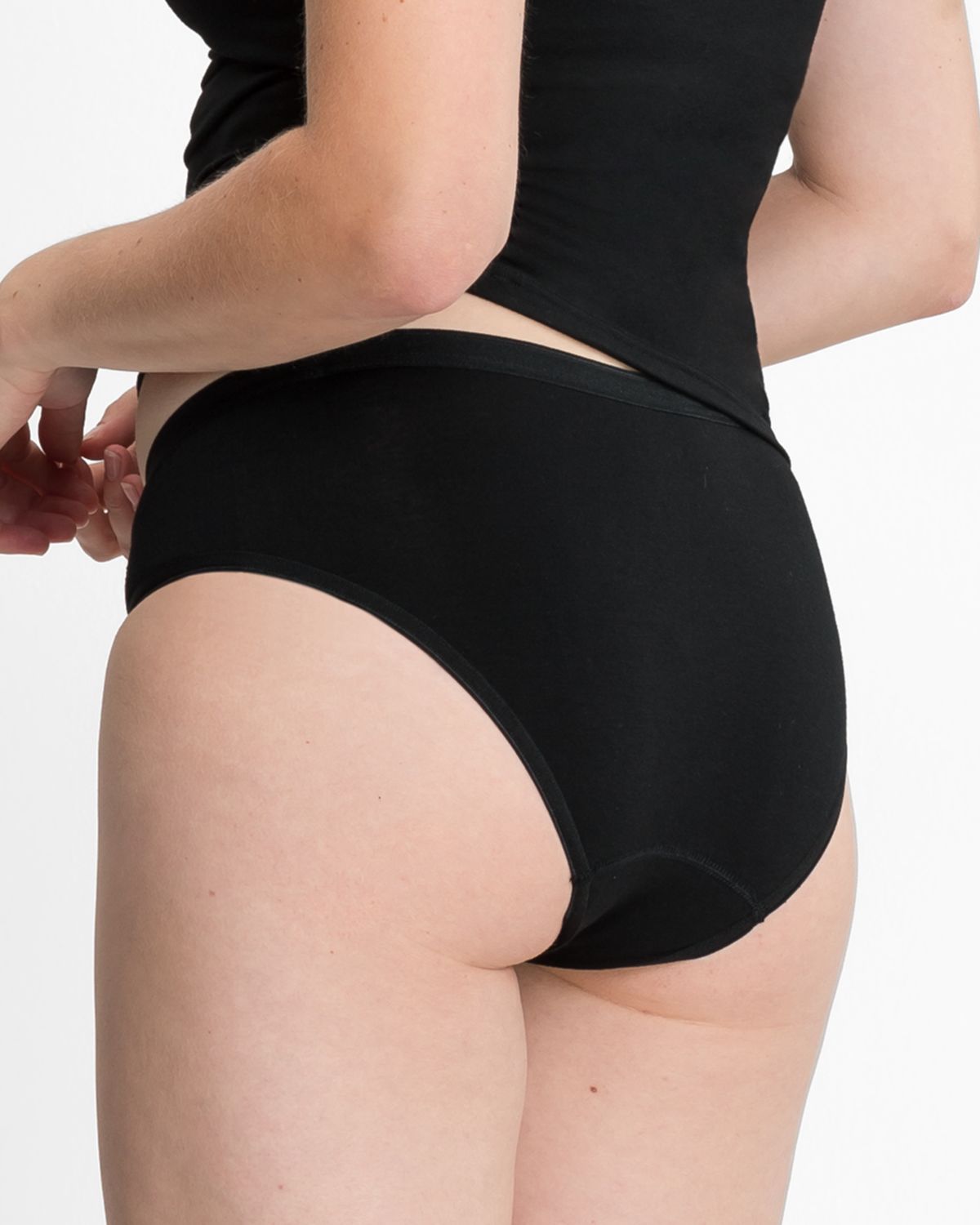 Model trägt Minislip in schwarz aus der Serie Bambus, Ansicht von hinten.