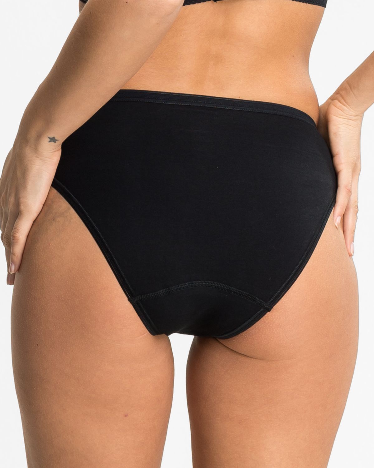 Model trägt Jazzpant in schwarz aus der Serie Britta, Ansicht von hinten.