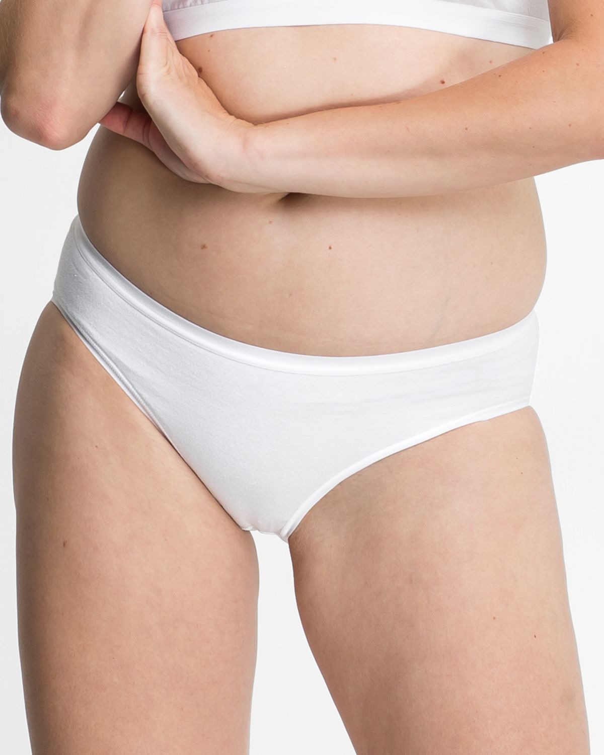 Model trägt Bikinislip in weiß aus der Serie Bio Cotton plus, Ansicht von vorne.