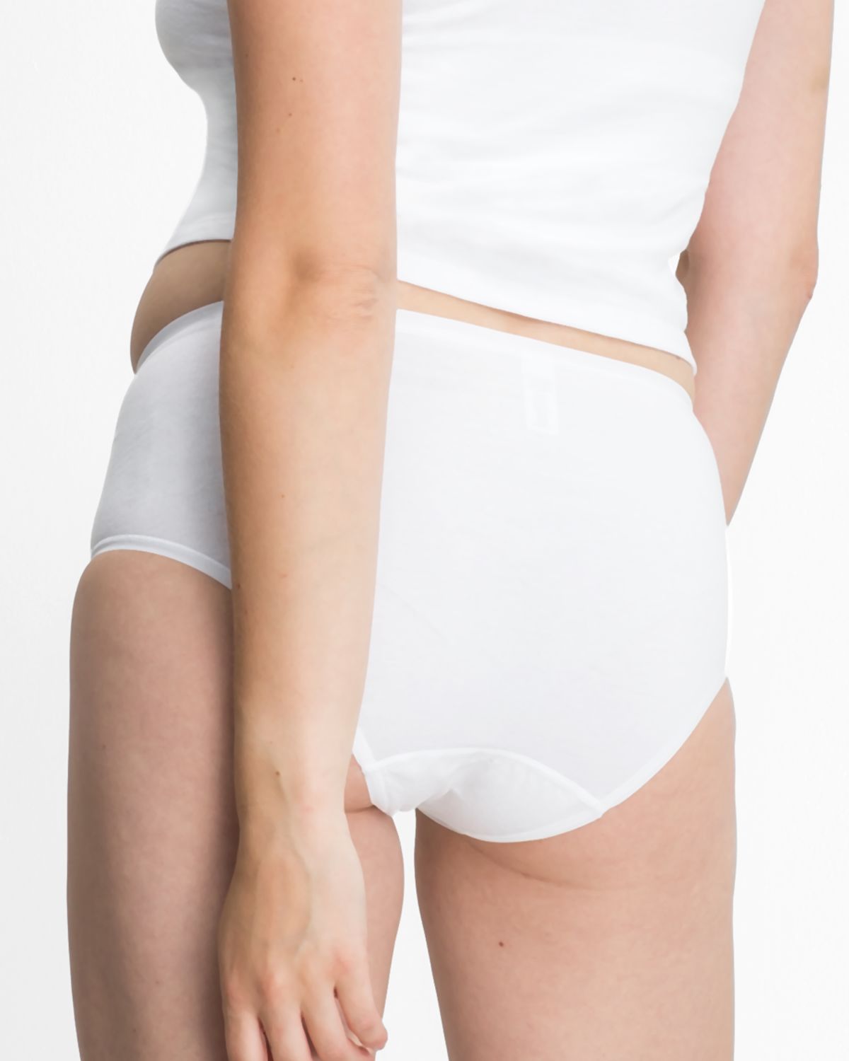 Model trägt Midislip in weiß aus der Serie Bio Cotton plus, Ansicht von hinten.