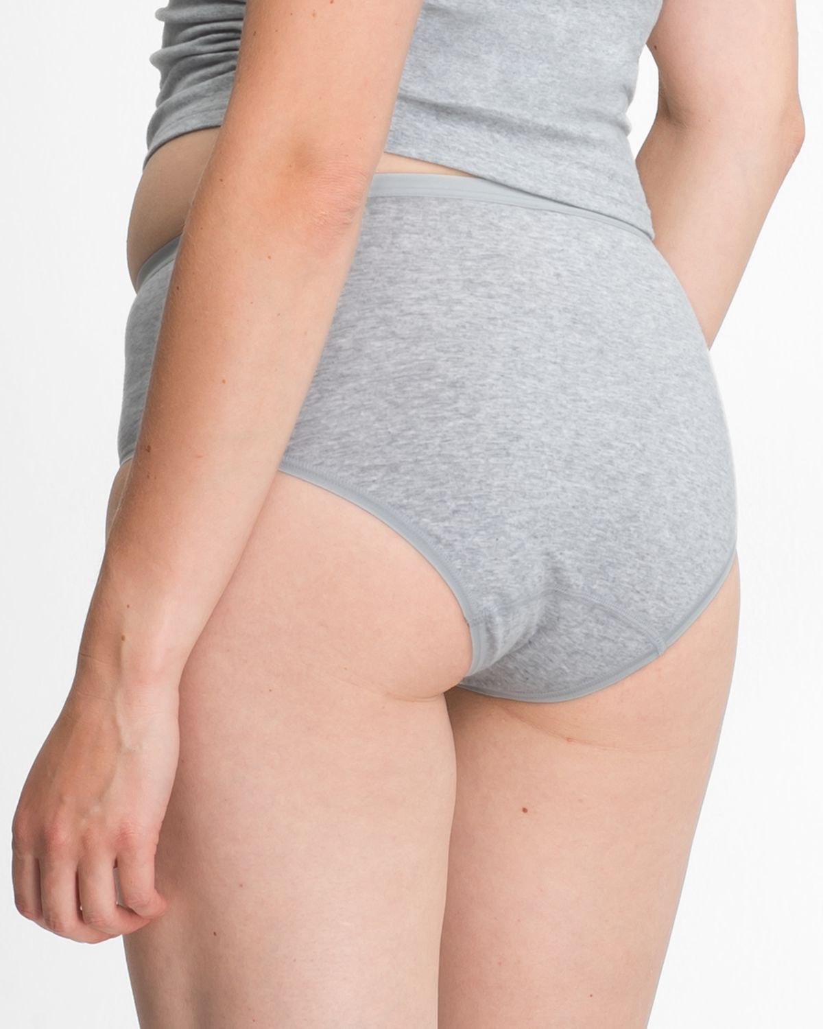 Model trägt Midislip in kiesel mélé aus der Serie Bio Cotton plus, Ansicht von hinten.