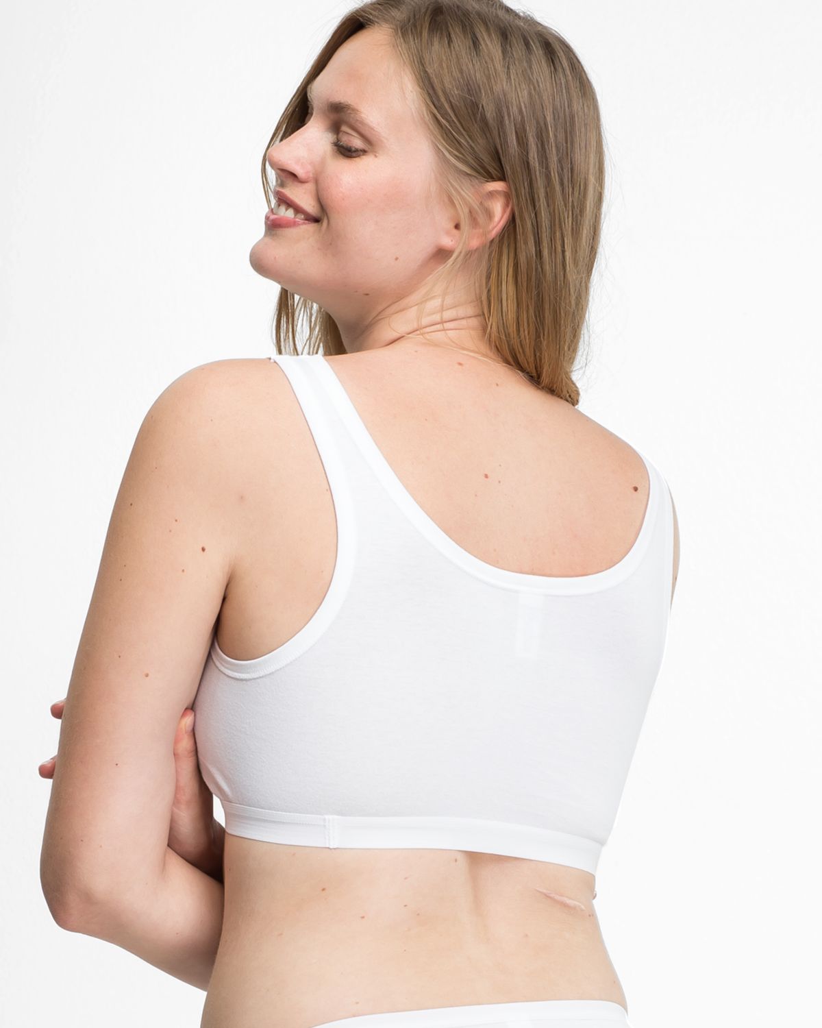 Model trägt Achselbustier in weiß aus der Serie Bio Cotton plus, Ansicht von hinten.