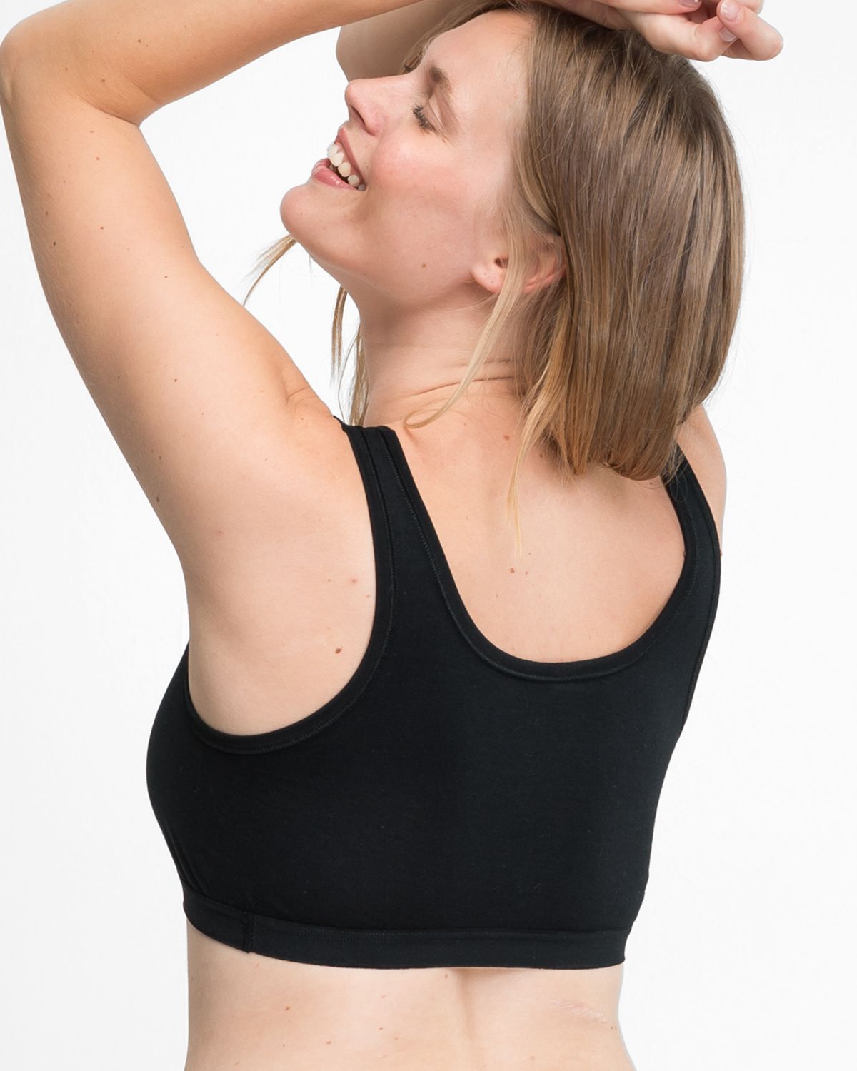 Model trägt Achselbustier in schwarz aus der Serie Bio Cotton plus, Ansicht von hinten.