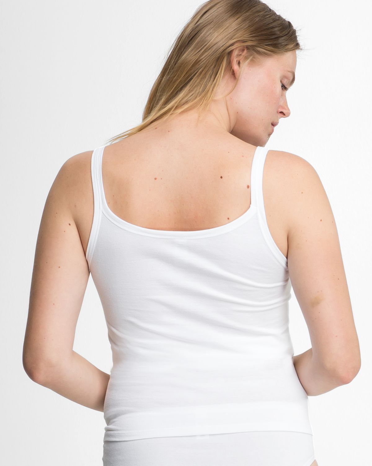 Model trägt Trägerhemd in weiß aus der Serie Bio Cotton plus, Ansicht von hinten.