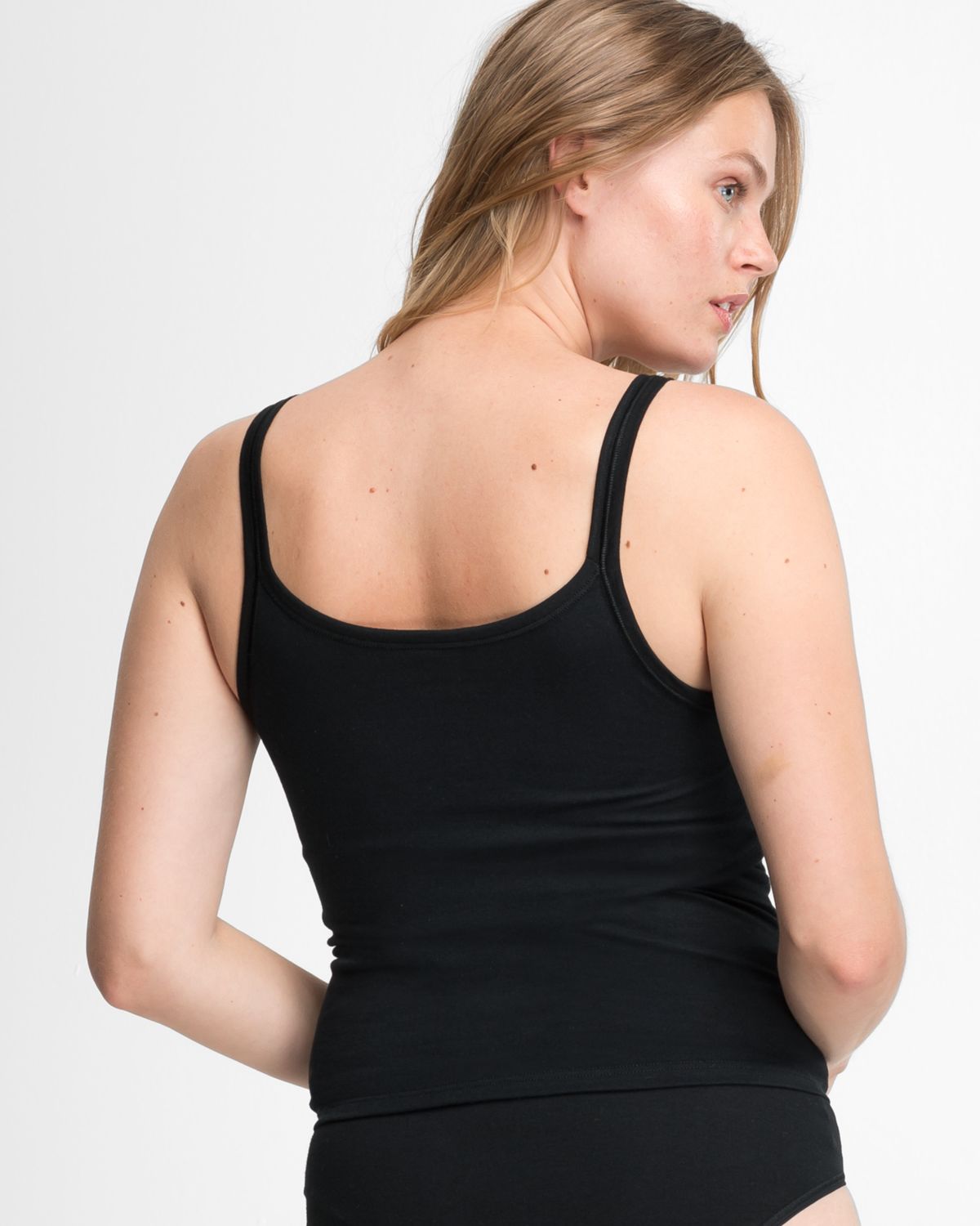 Model trägt Trägerhemd in schwarz aus der Serie Bio Cotton plus, Ansicht von hinten.