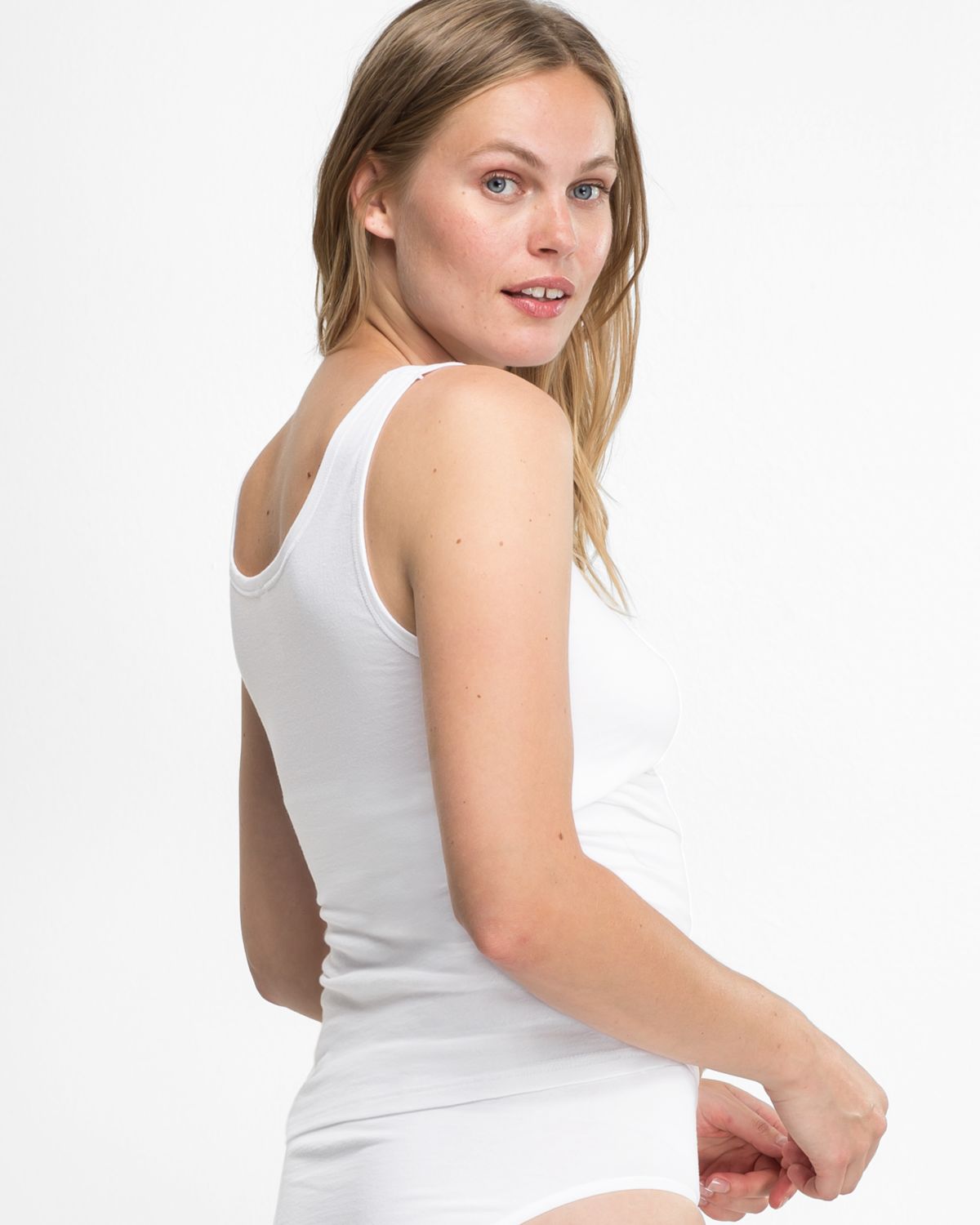 Model trägt Achselhemd in weiß aus der Serie Bio Cotton plus, Ansicht von hinten.