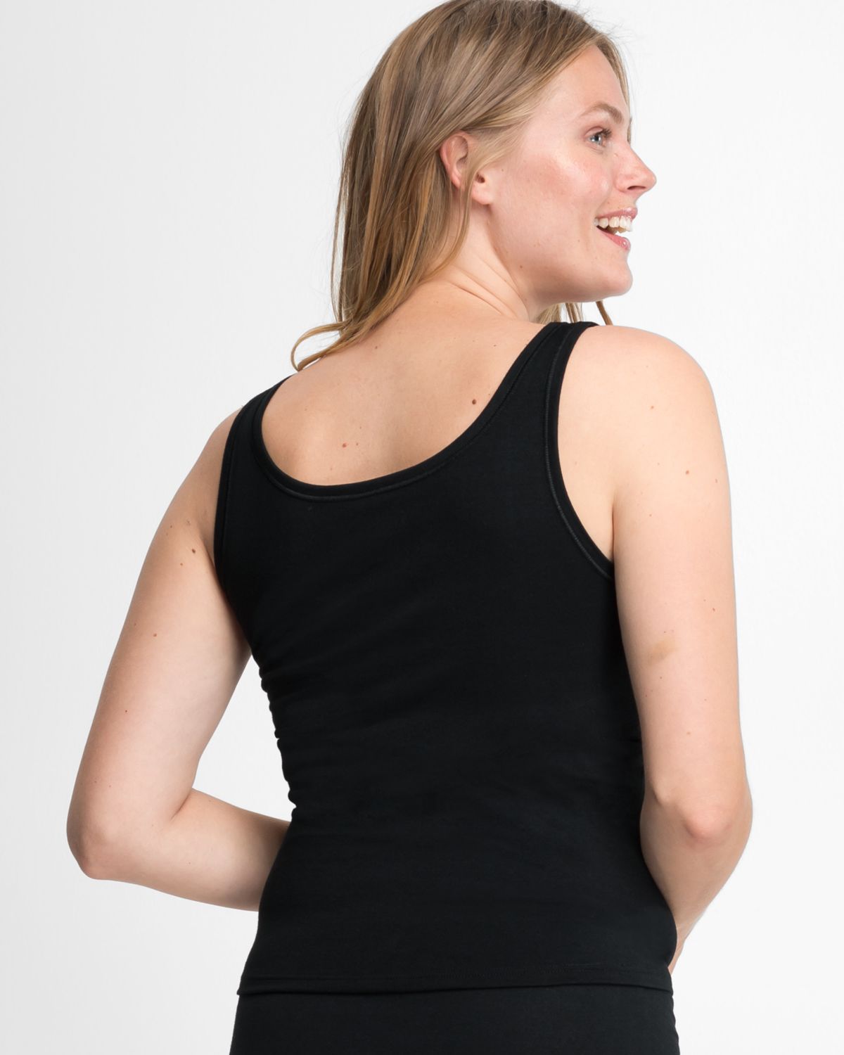 Model trägt Achselhemd in schwarz aus der Serie Bio Cotton plus, Ansicht von hinten.