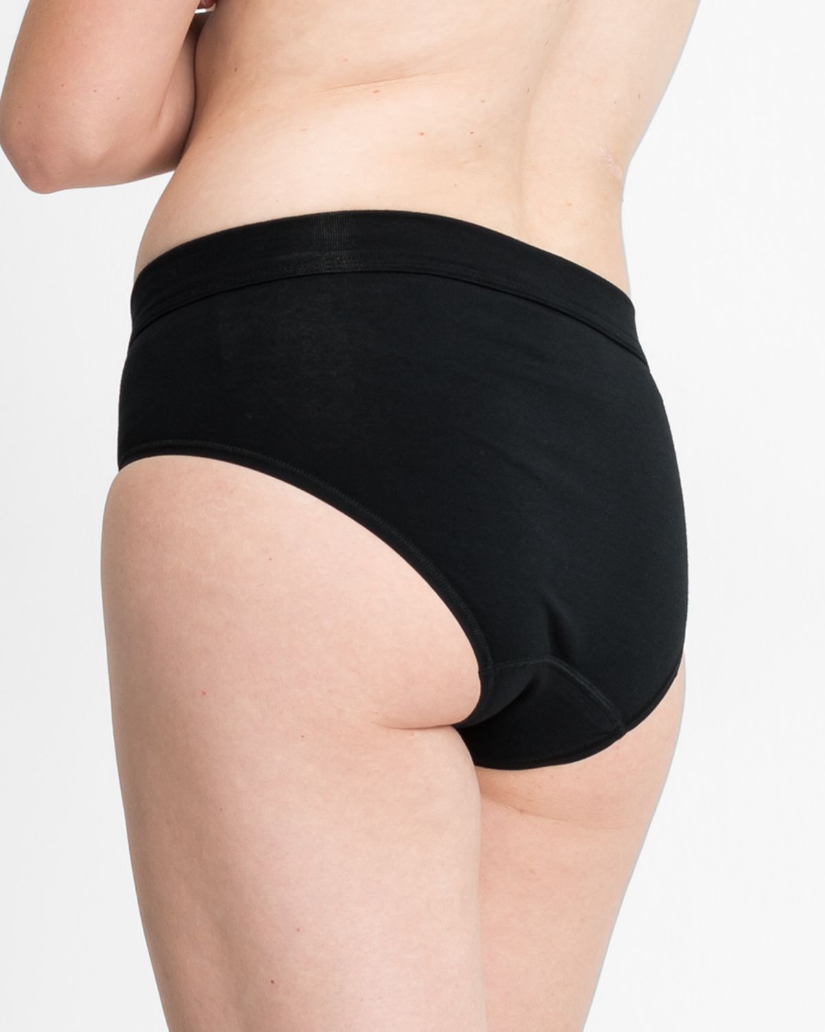 Model trägt Midislip in schwarz aus der Serie Bio Cotton plus, Ansicht von hinten.