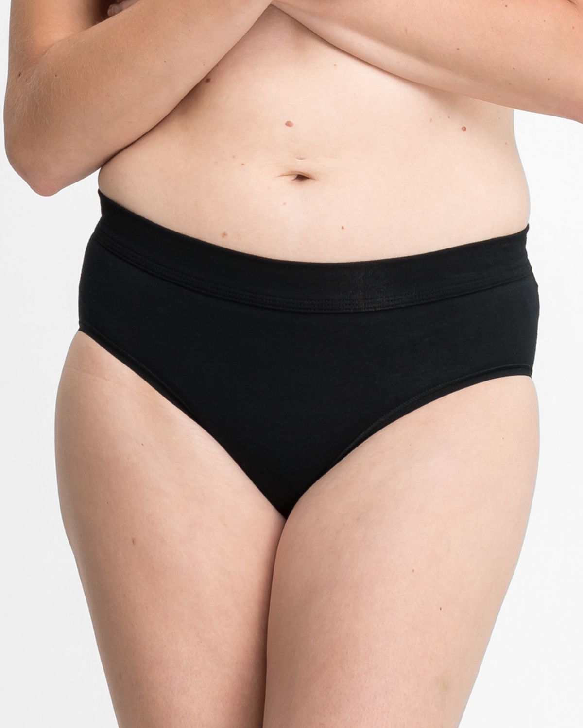 Model trägt Midislip in schwarz aus der Serie Bio Cotton plus, Ansicht von vorne.