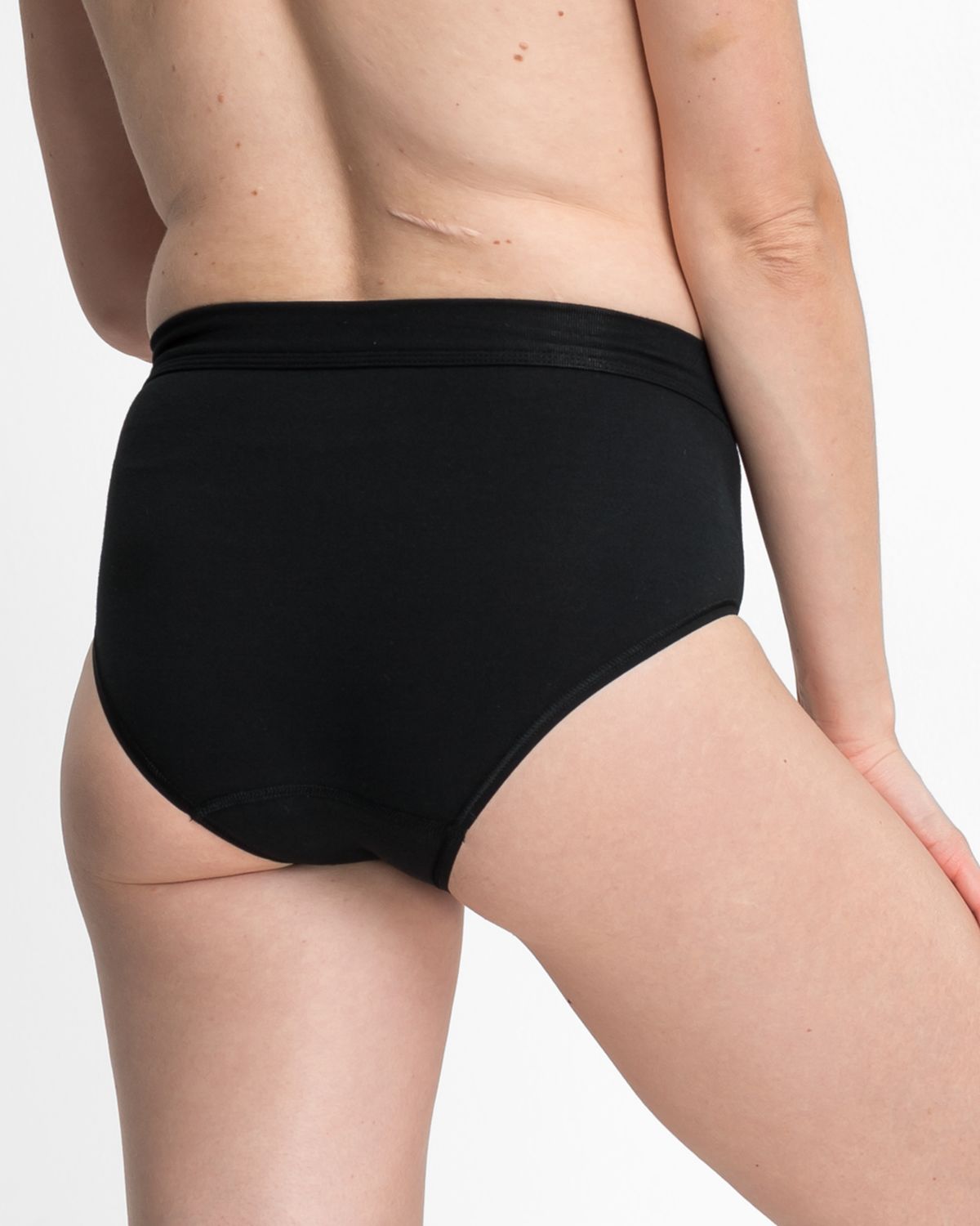 Model trägt Maxislip in schwarz aus der Serie Bio Cotton plus, Ansicht von hinten.